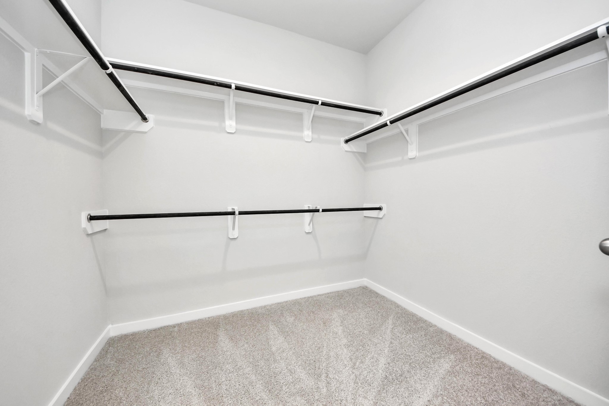Walk-in closet that epitomizes luxury and practicality. This generously sized space features built-in shelving, offering abundant room for impeccable organization. High ceilings and recessed lighting create a bright and welcoming ambiance. Sample photo of completed home with similar floor plan. Actual colors and selections may vary.