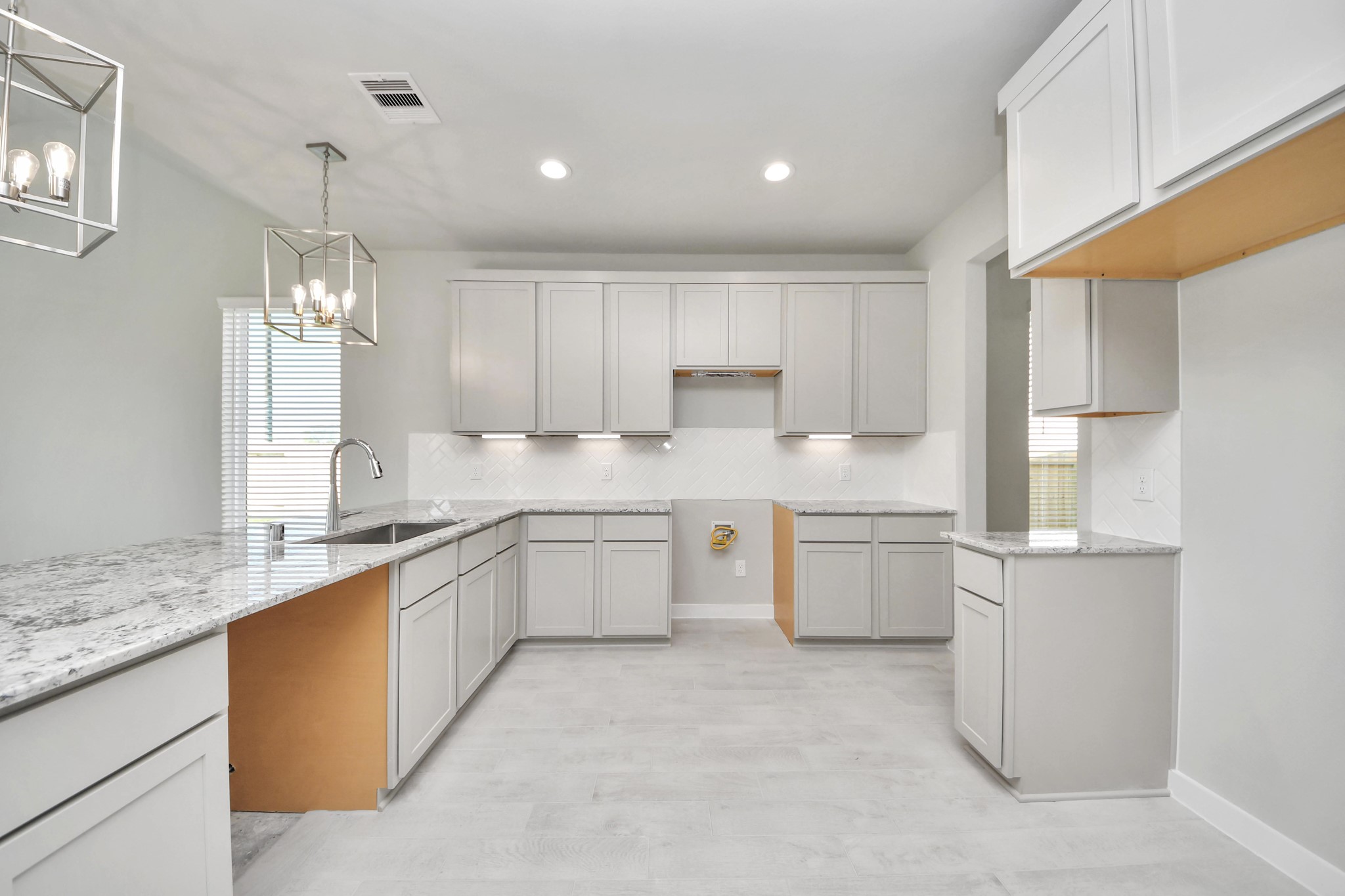 The kitchen is a culinary haven, featuring granite countertops, a tile backsplash, stainless steel appliances, 42 upper cabinets, and undercabinet lighting. Sample photo of completed home with similar floor plan. Actual colors and selections may vary. The kitchen is a culinary haven, featuring granite countertops, a tile backsplash, stainless steel appliances, 42 upper cabinets, and undercabinet lighting. Sample photo of completed home with similar floor plan. Actual colors and selections may vary.
