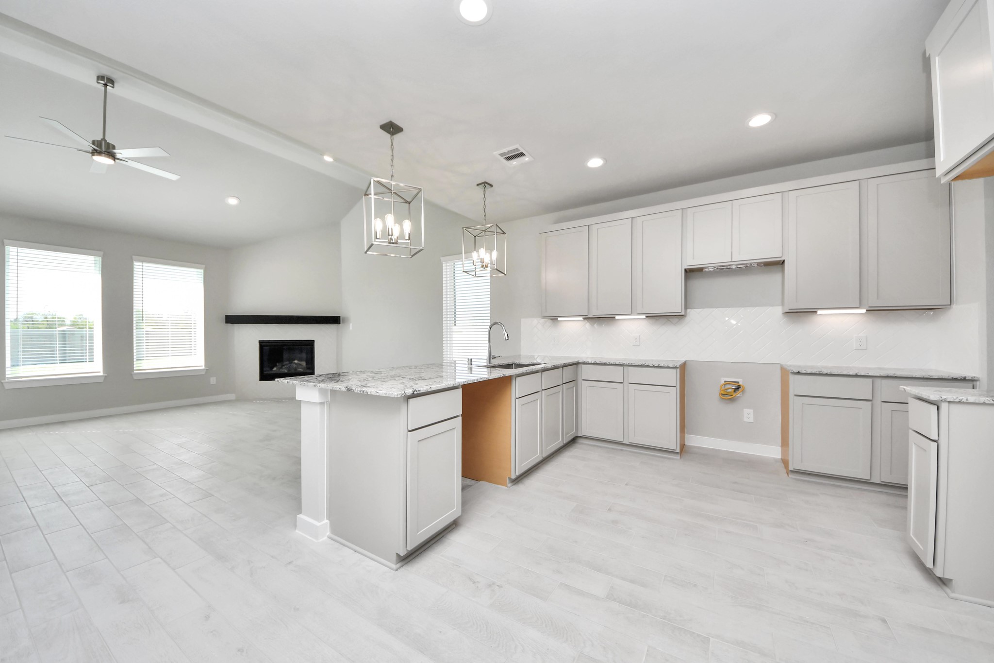 This kitchen is truly a chef's dream! This haven Boasts high ceilings, recessed & pendant lighting, stained wood cabinets, granite countertops, stainless steel appliances, a modern tile backsplash. All of this overlooks your expansive family room, creating a perfect space for culinary delights and family gatherings. Sample photo of completed home with similar floor plan. Actual colors and selections may vary. This kitchen is truly a chef's dream! This haven Boasts high ceilings, recessed & pendant lighting, stained wood cabinets, granite countertops, stainless steel appliances, a modern tile backsplash. All of this overlooks your expansive family room, creating a perfect space for culinary delights and family gatherings. Sample photo of completed home with similar floor plan. Actual colors and selections may vary.