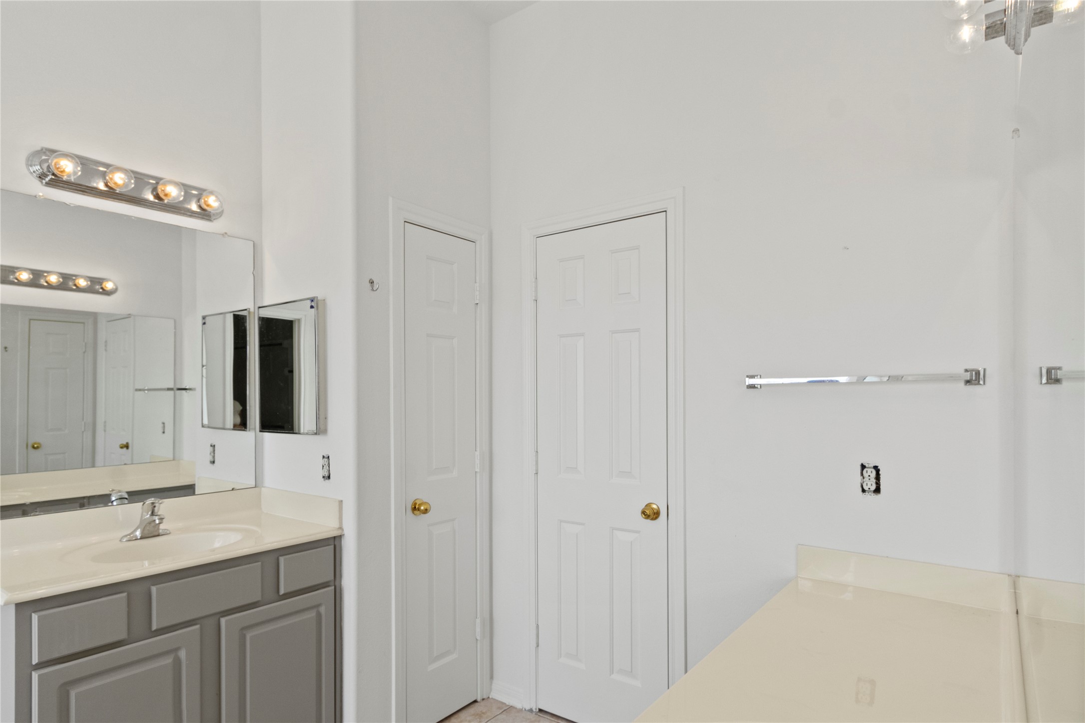 Primary bathroom featuring dual vanities, ample counter space, large mirrors, and neutral finishes for a clean, functional design