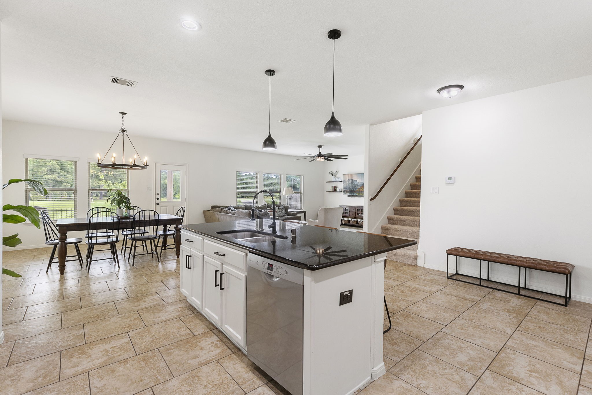 Updated lighting, neutral paint and oversized tile highlight this downstairs living area.