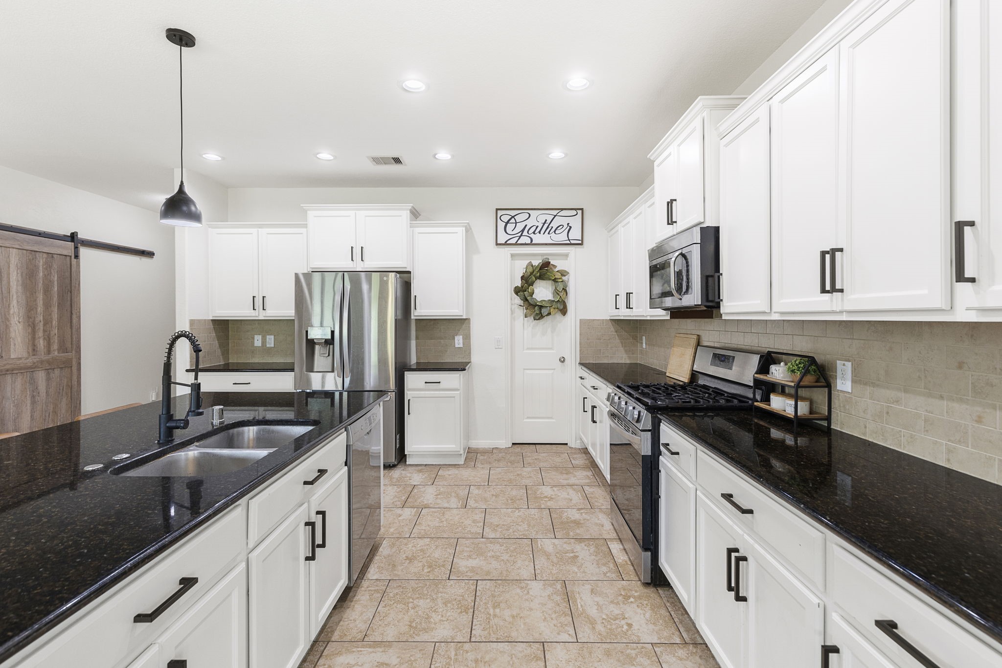 This kitchen features stainless appliances and large walk-in pantry.