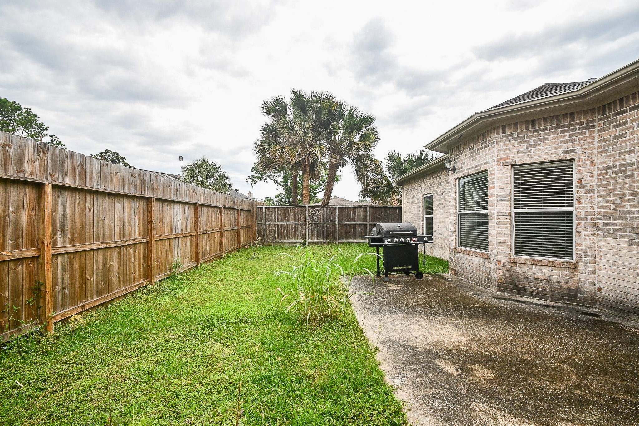 A private, fenced backyard featuring a cozy lawn. A private, fenced backyard featuring a cozy lawn.
