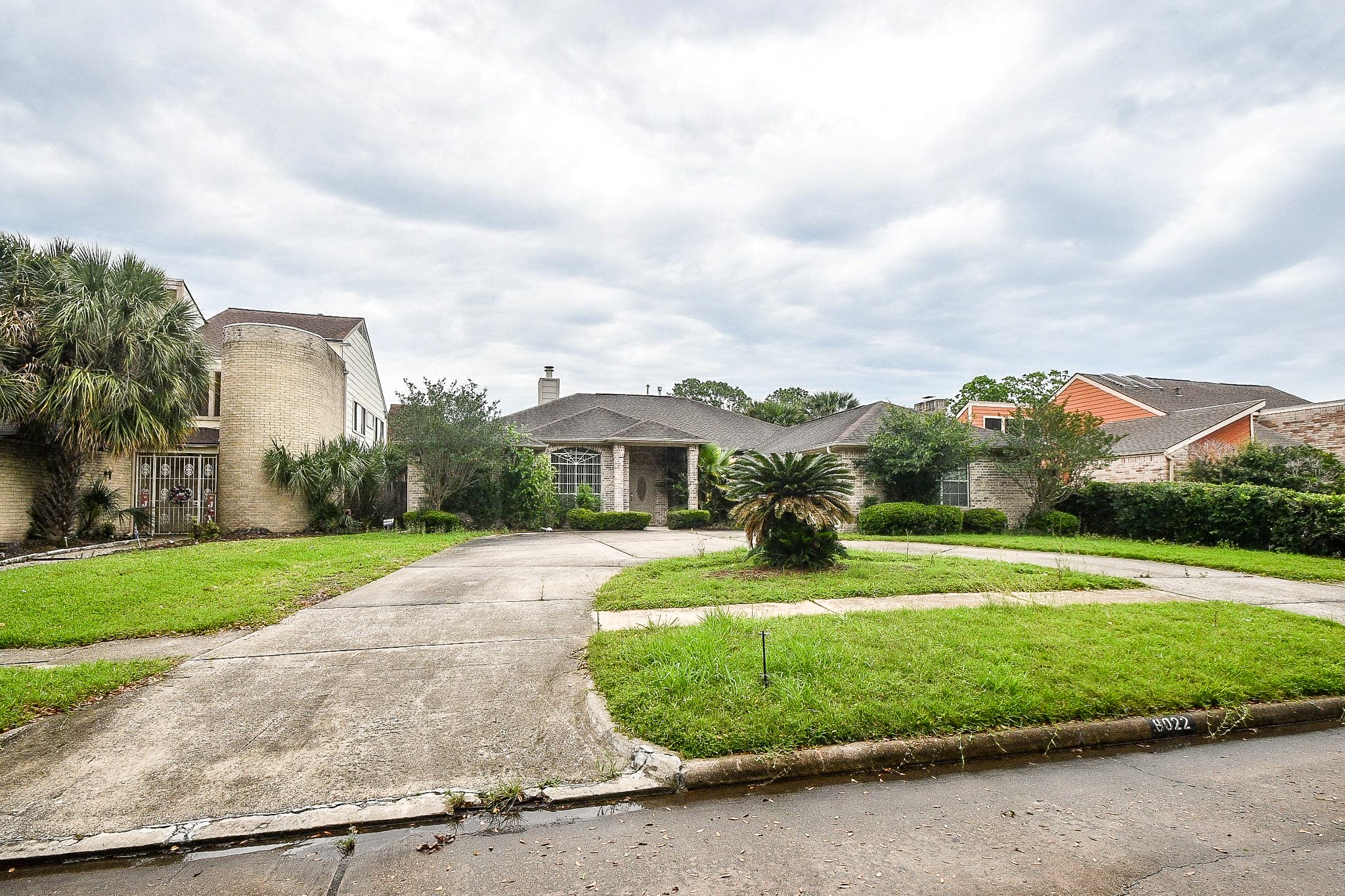Stunning front yard with lush landscaping and mature palm trees.