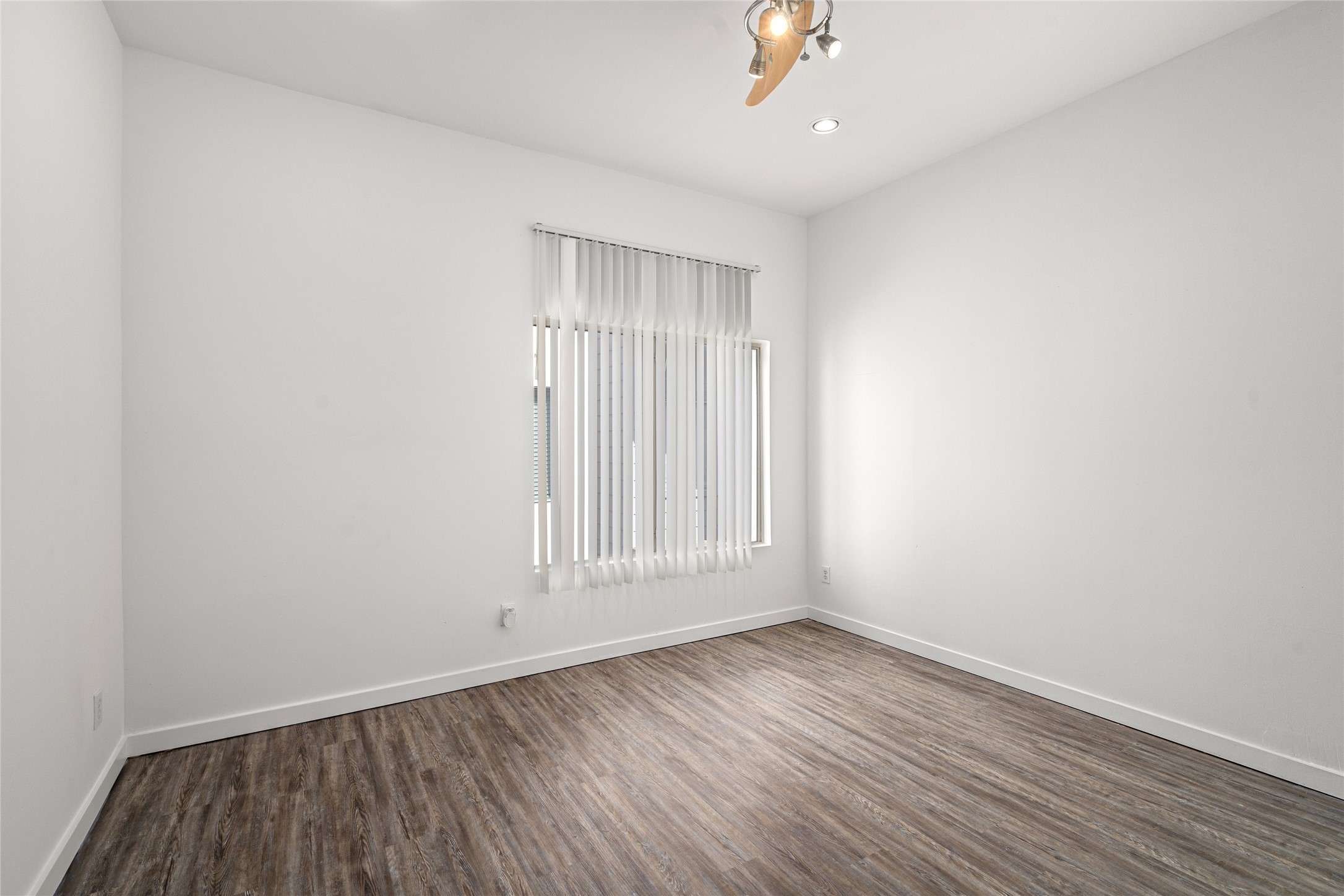 Serene primary bedroom offering ample space for relaxation, featuring large windows that invite natural light and a peaceful atmosphere to unwind after a long day.