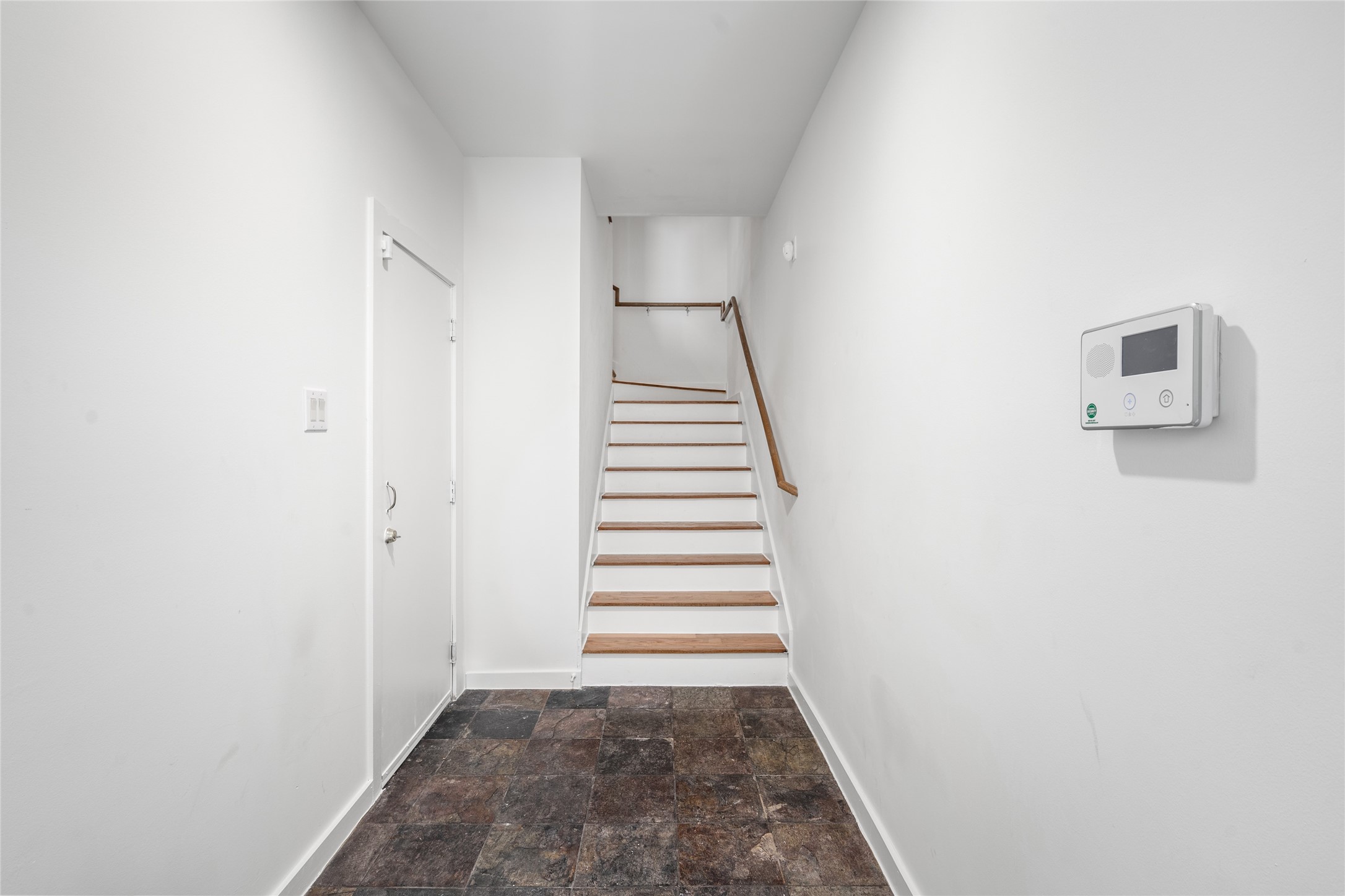Bright entryway featuring sleek stairs and easy access to upstairs treasures.