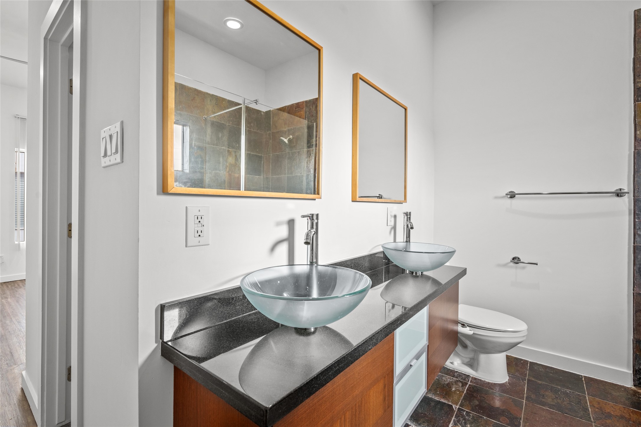 Luxurious primary bathroom featuring dual vessel sinks and a lavish shower, combining elegance with modern comfort.