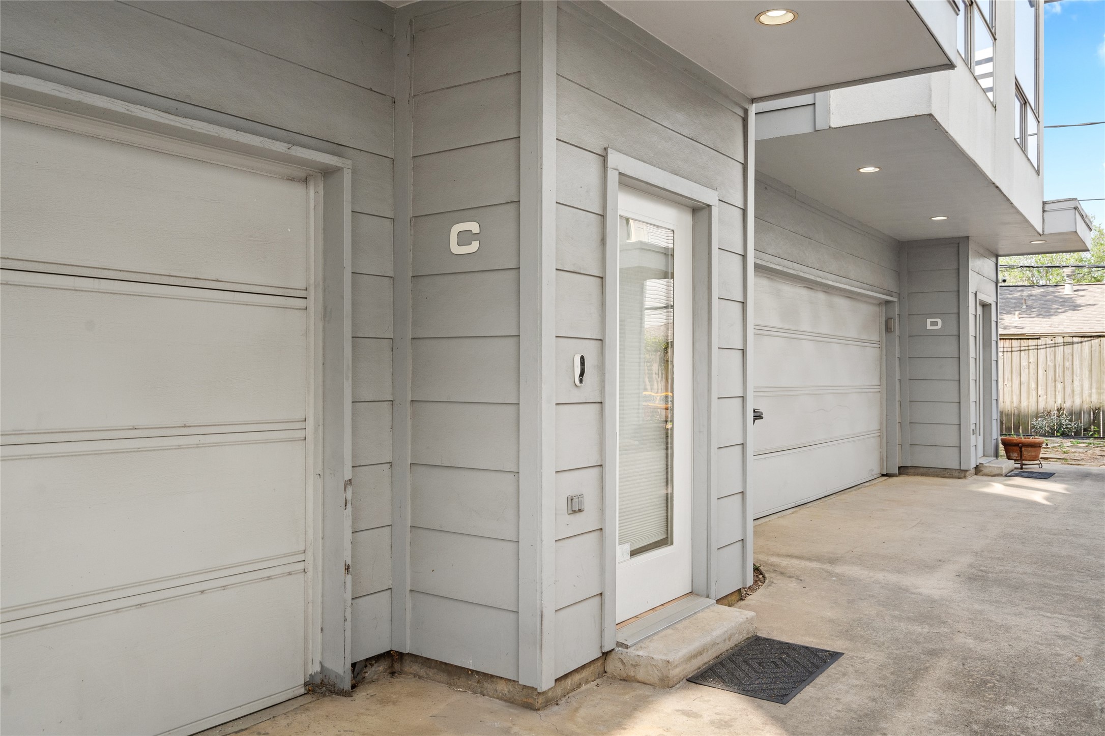 Private entryway with a modern glass-paneled door, complemented by a covered entrance for added convenience. The attached two-car garage provides secure parking and additional storage space.