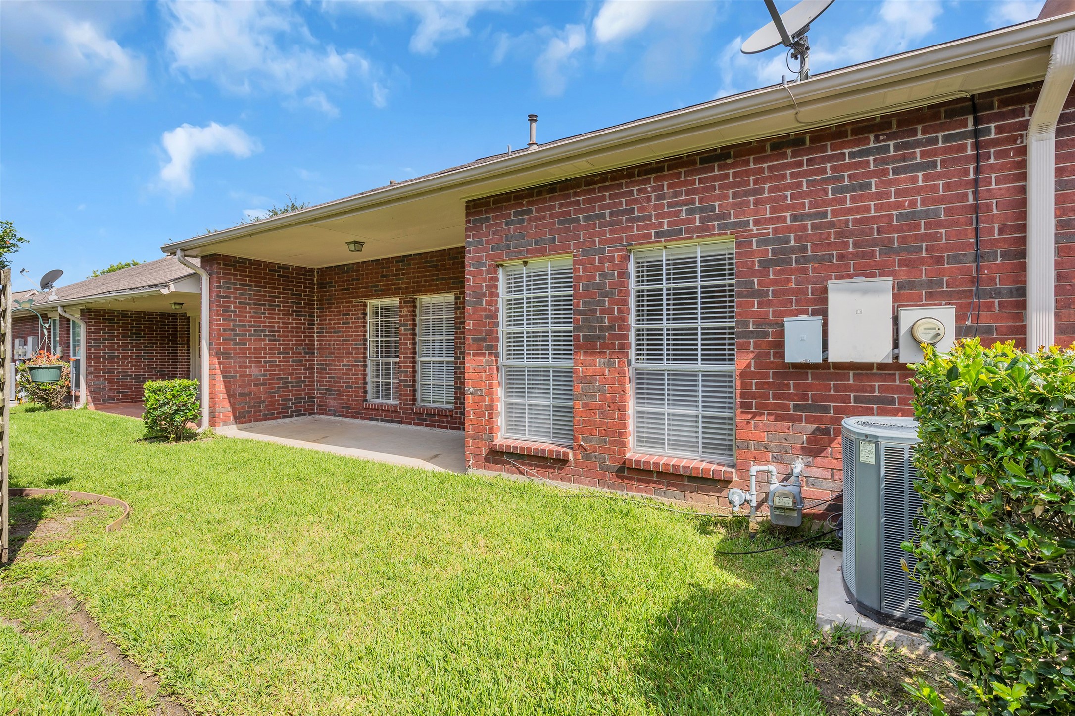 Rear view of the home showcasing classic red brick exterior walls, highlighting a solid and timeless finish at the back of the property.