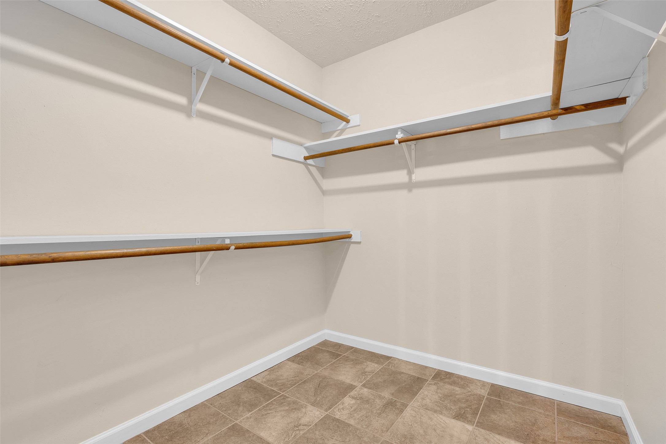 Walk-in closet in the primary bedroom featuring built-in shelves and hanging rods, providing organized storage space for clothing, shoes, and accessories.
