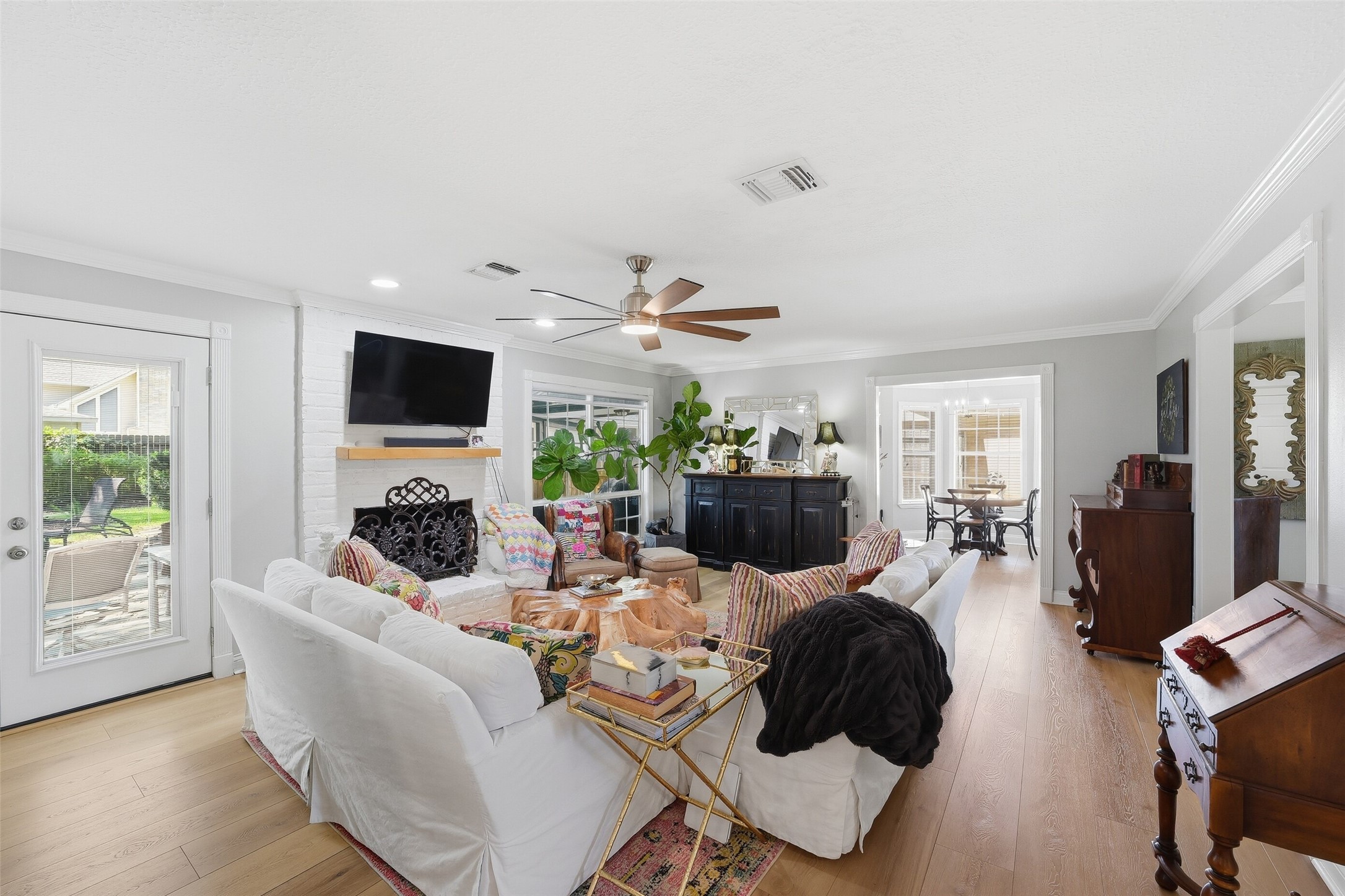 Family room with lots of sunlight and a gas log fireplace.  Notice the beautiful warm wood like flooring throughout.