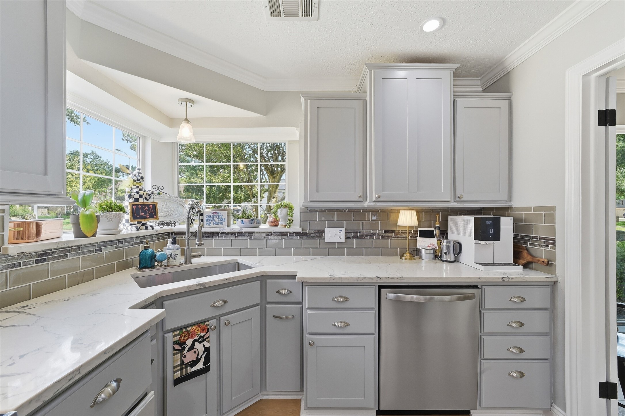 Sunshine filled kitchen with quartz countertops and great appliances.