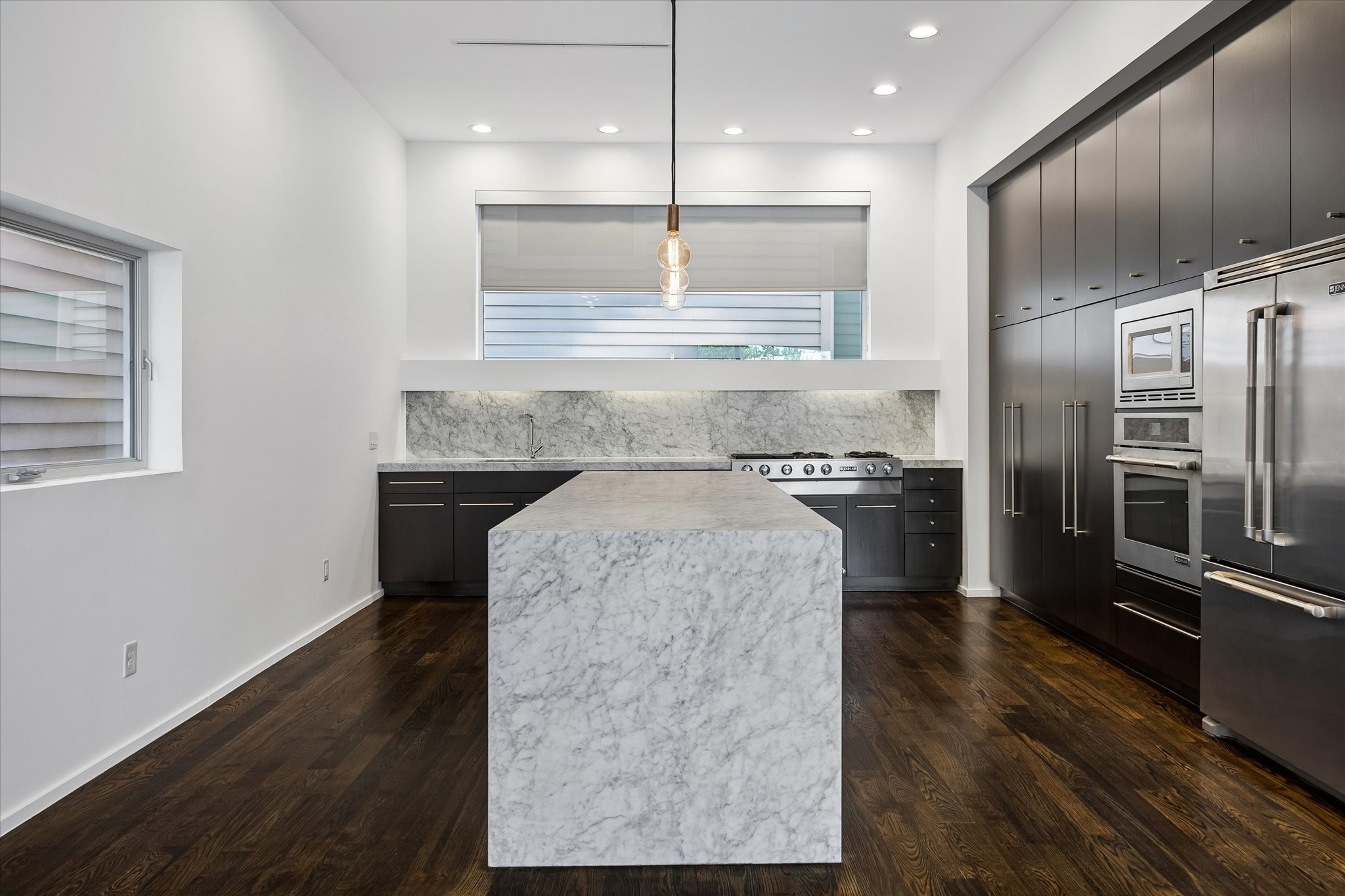 The centerpiece of the kitchen is this stunning Carrara marble island with waterfall edge that provides ample room for prep work and seating when entertaining.