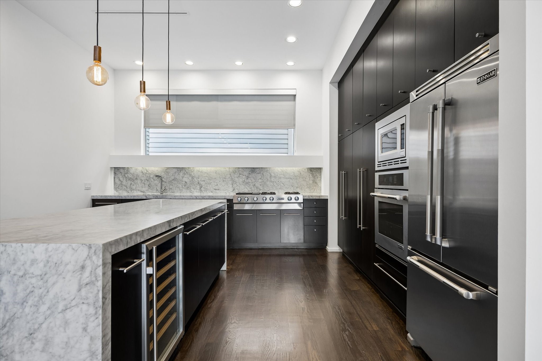 The kitchen features high-end stainless appliances including a Jenn-Air refrigerator, wall oven and microwave and gas cooktop. There is also a wine refrigerator that is included!
