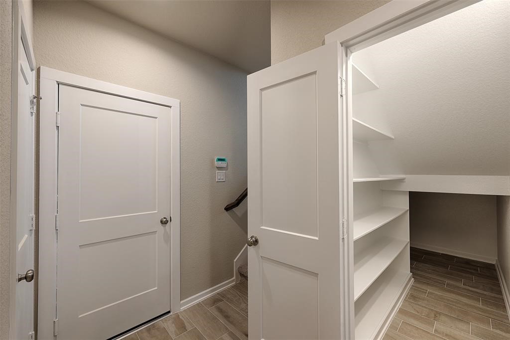 Huge walk in closet with ample shelving for storage.