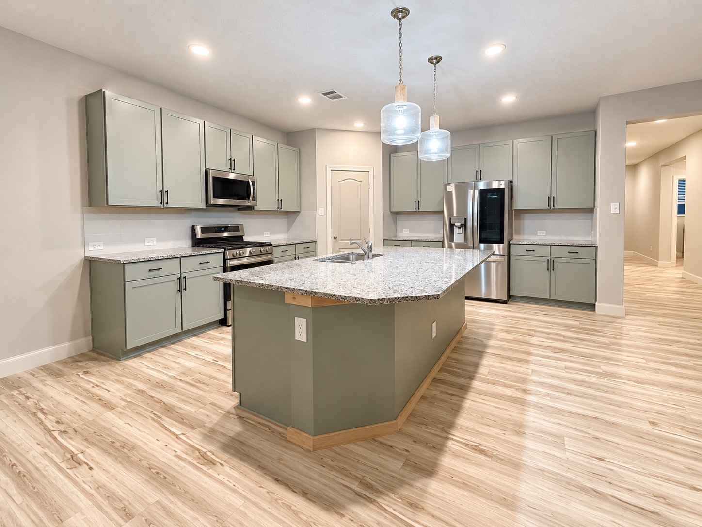 The kitchen island is generously sized, perfect for baking or enjoying breakfast, and creates an open-concept flow into the living area.