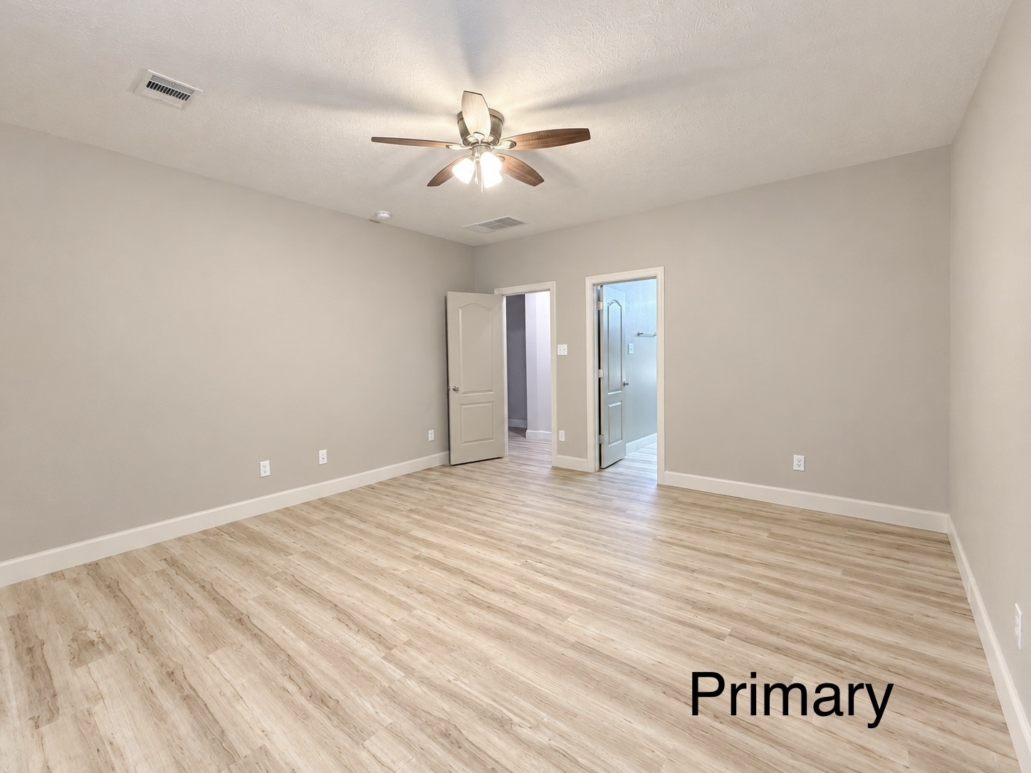 The primary bedroom is conveniently located off the living space and separate from the other bedrooms, offering a private retreat.