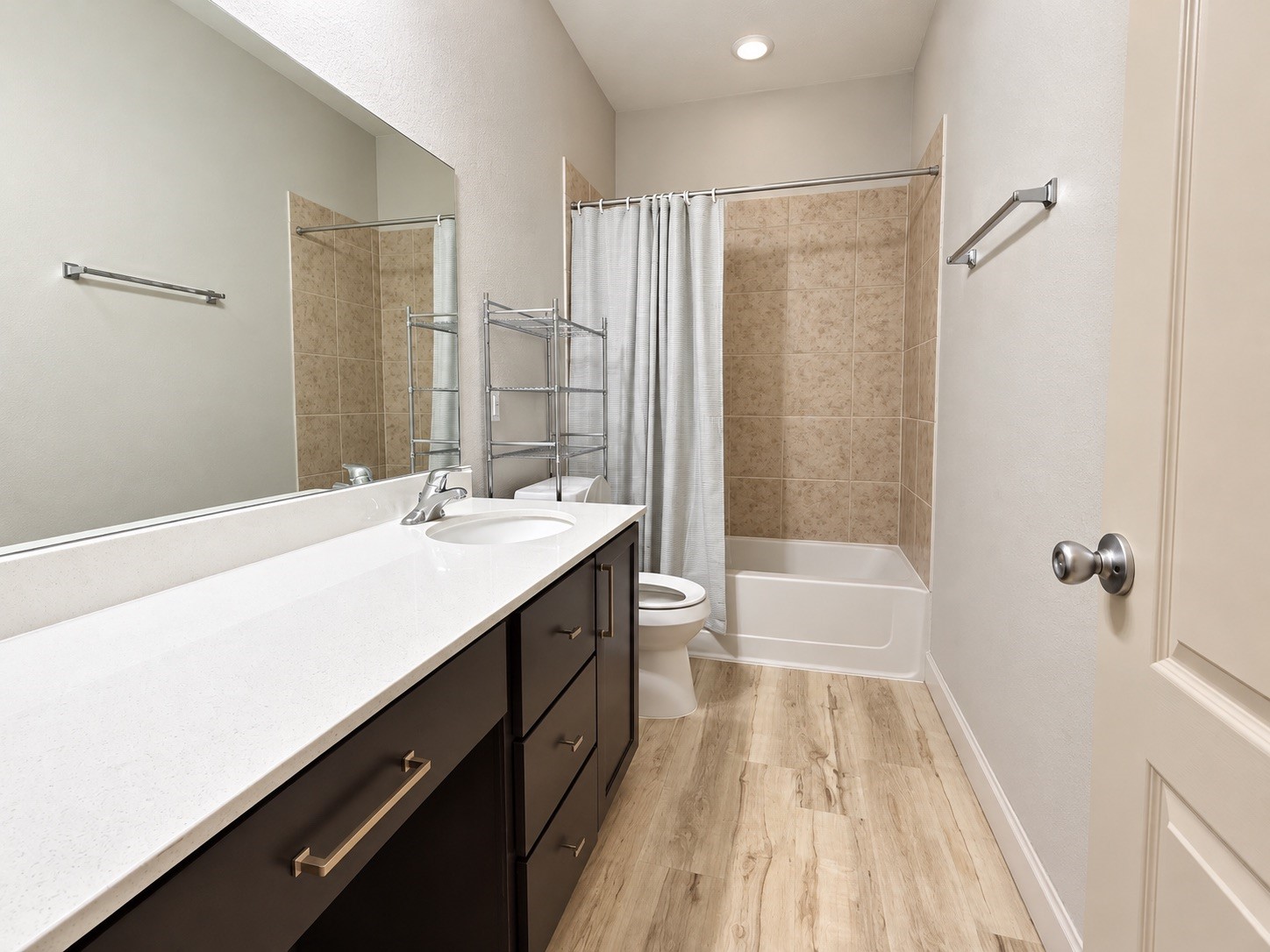 The second bathroom features a shower-tub combination, along with vanity space and is conveniently situated between the secondary bedrooms.
