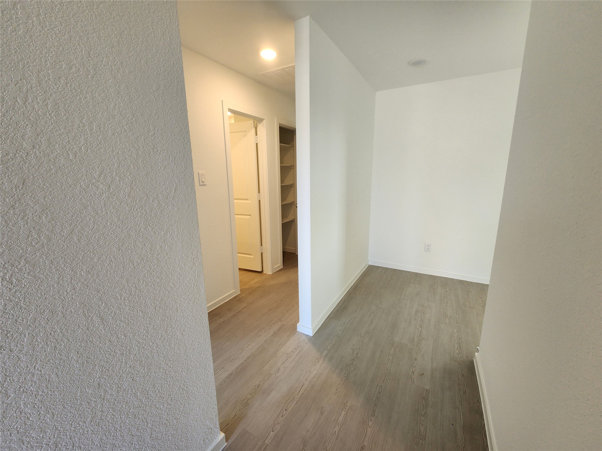 Entry way leading from front door leads to a hallway with entrances to two secondary bedrooms and secondary bathroom. Straight ahead leads to open concept living area/kitchen.