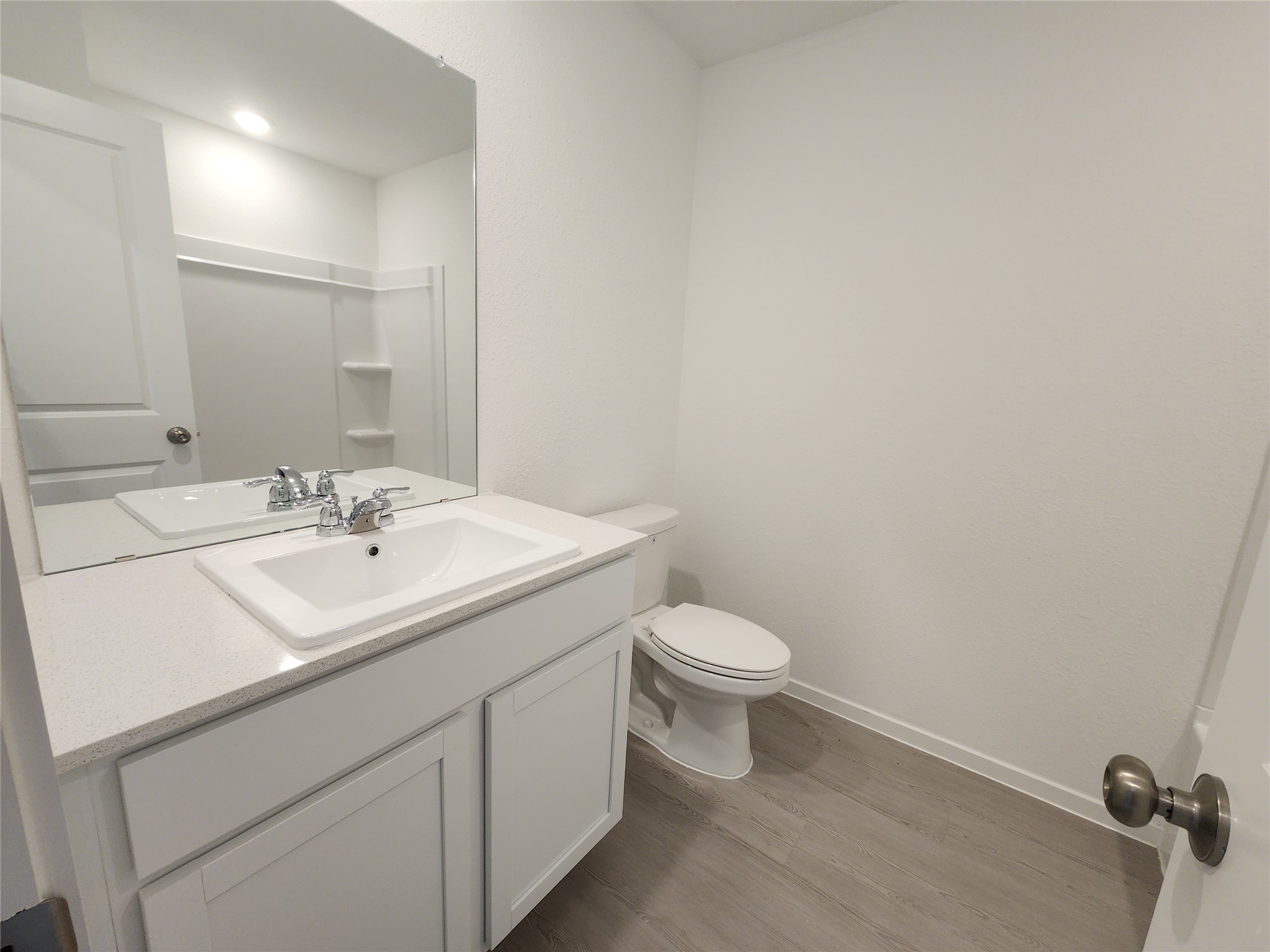 Secondary bathroom features a modern design with a white vanity, spacious countertop, large mirror, and a tub/shower combo.