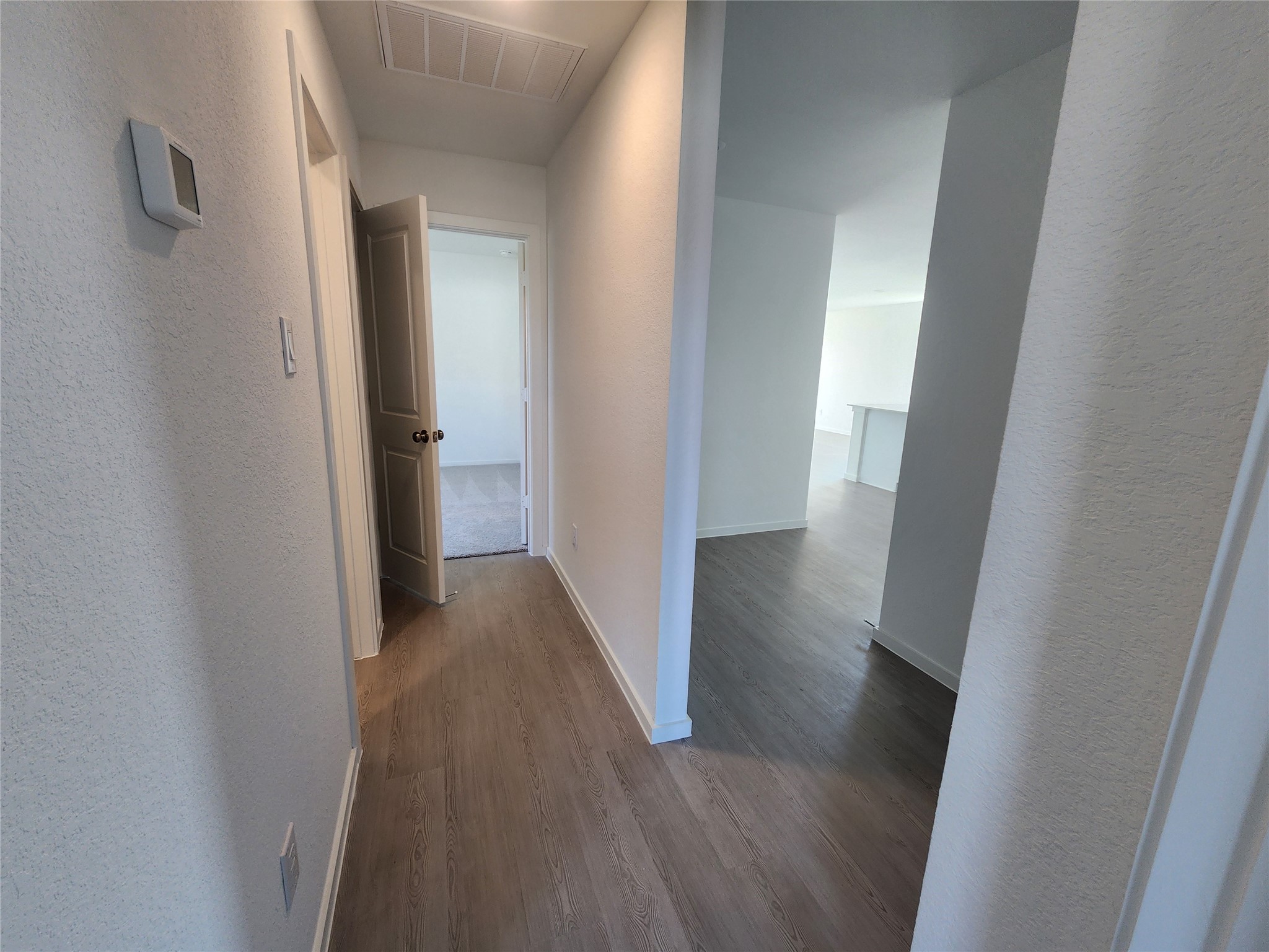 Another view of the hallway with entrances to bedrooms, secondary bathroom.