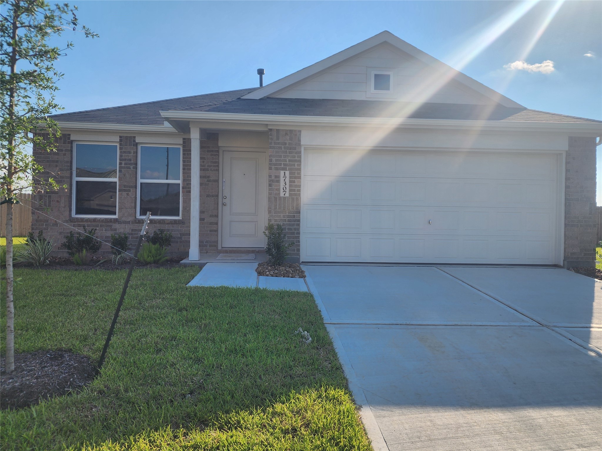 Modern, single-story brick home with a two-car garage and a neat front yard. The entrance features a small porch to welcome you to your new home!