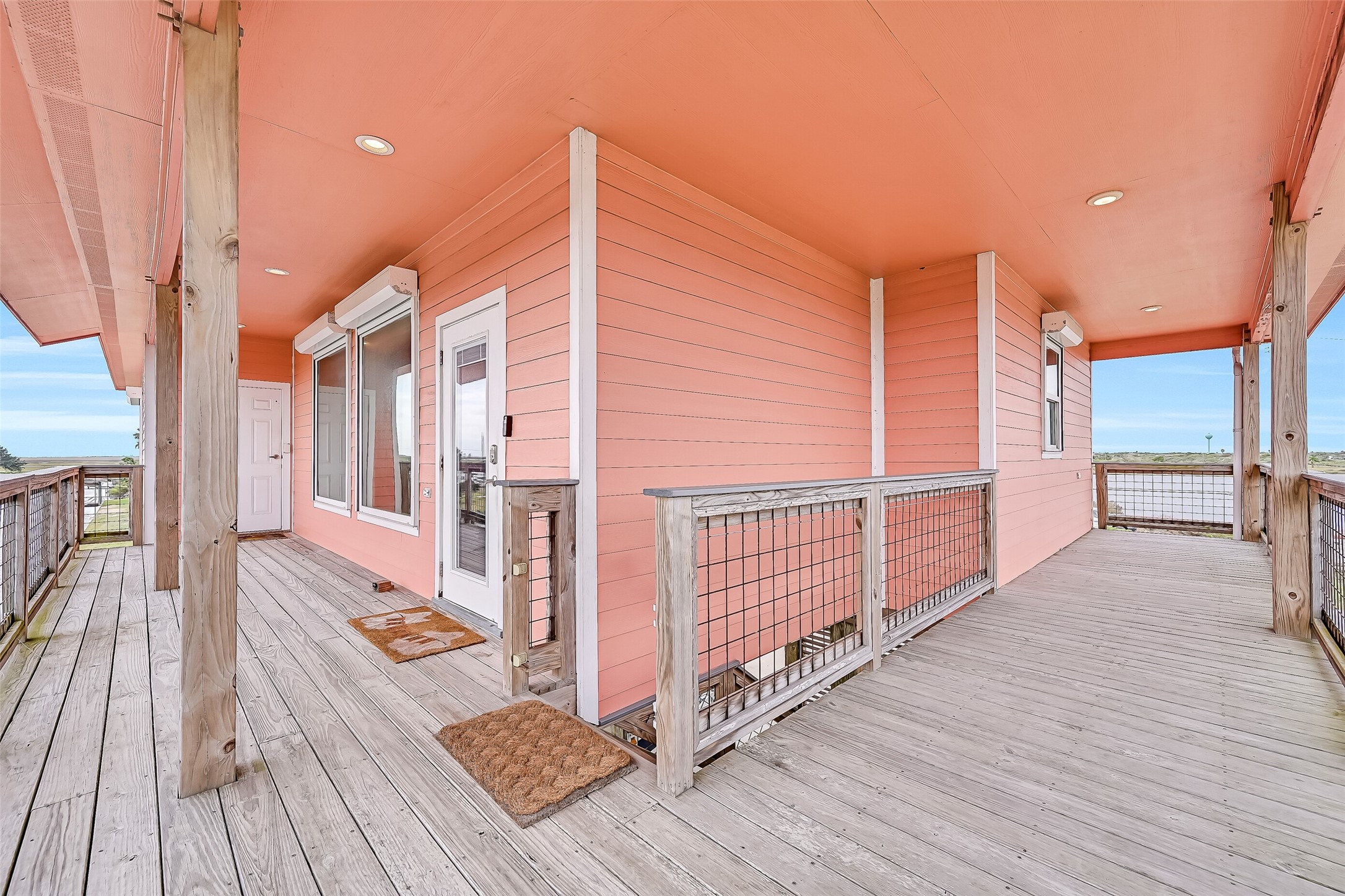 Enjoy fabulous sunrises and sunsets from the comfort of your covered deck. Even the stairs leading to the main level are covered and lead directly to the covered entertaining / parking areas under the home. The 6 panel door to the left of the picture windows access a full elevator and not just a cargo lift- yes that is right! This home offers the ultimate in accessibility thanks to a residential elevator.