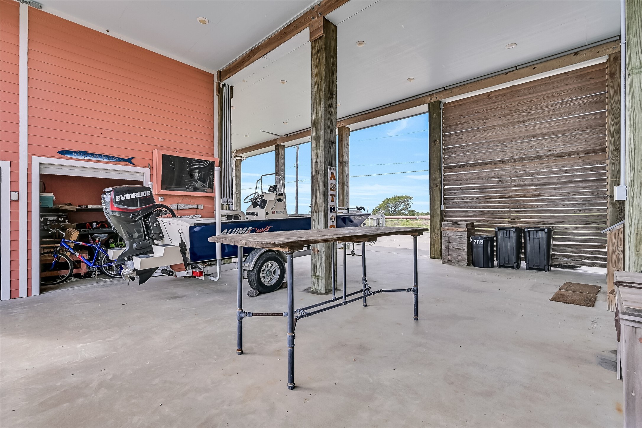 Open the shutter door to reveal a storage room, with a work space.