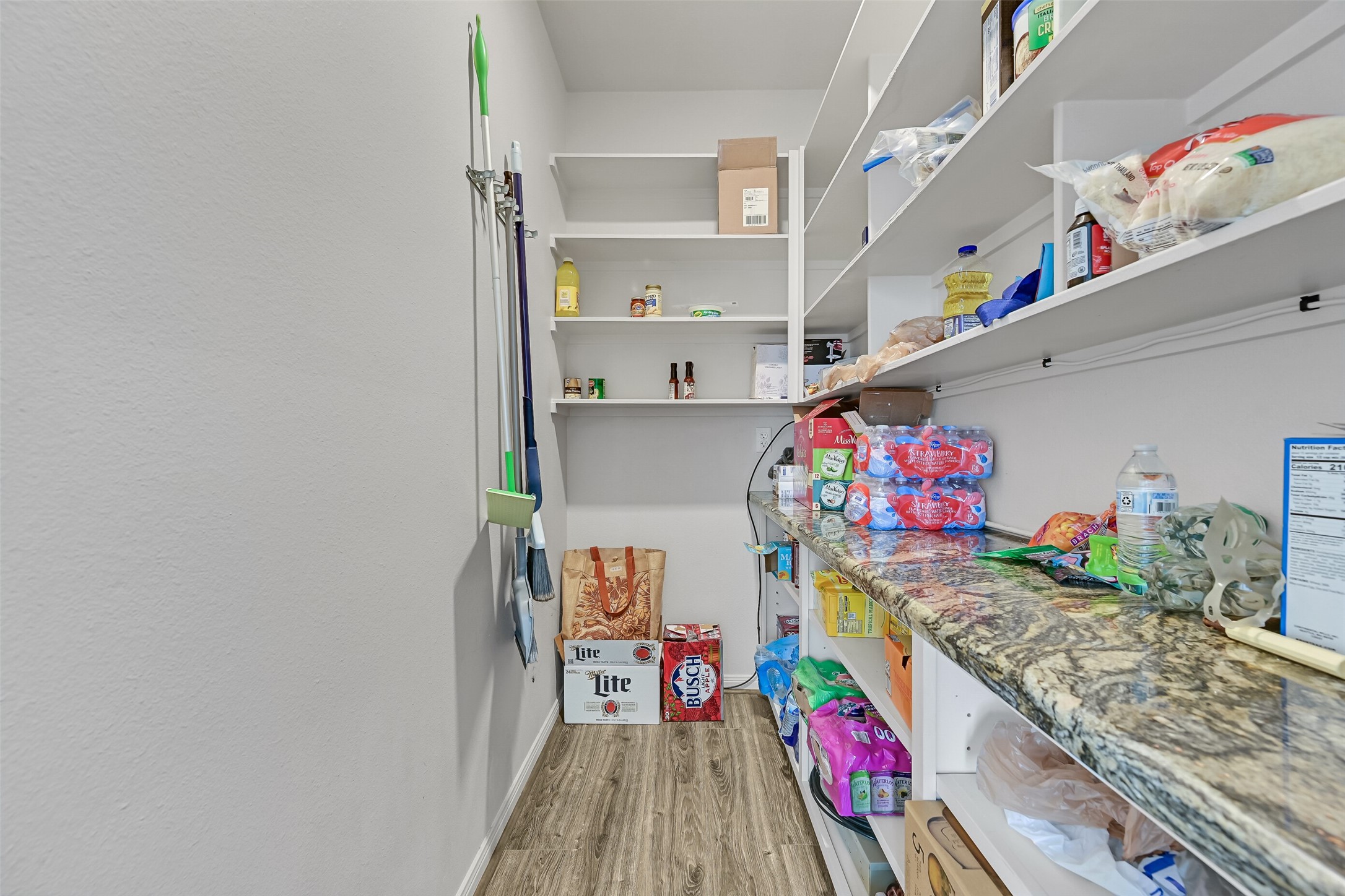 Here is your oversized walk-in pantry! Something you don't even find in homes these days - well this is the one that will cater to all of your Costco runs! Notice the luxurious granite spills into the pantry.