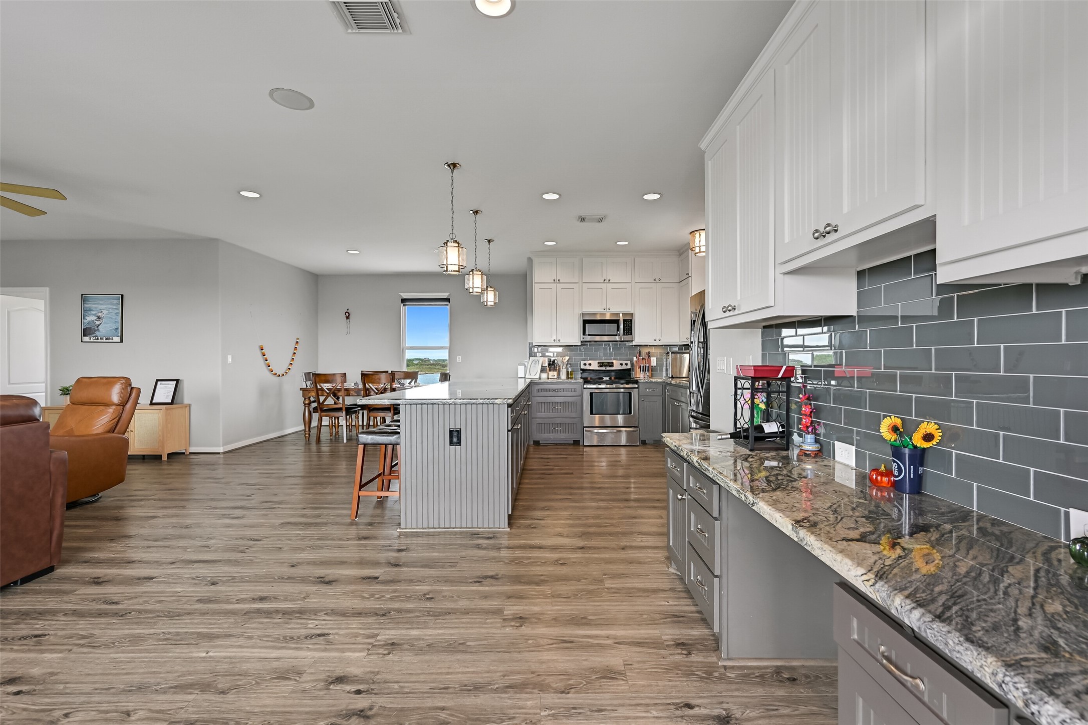 Upon entering, an open floorplan greets you, immersed in modern neutral tones. The workspace just off the entry would also make a perfect drybar or coffee bar. Notice the beautiful silver cloud granite counter top, which is also found throughout the rest of the home.