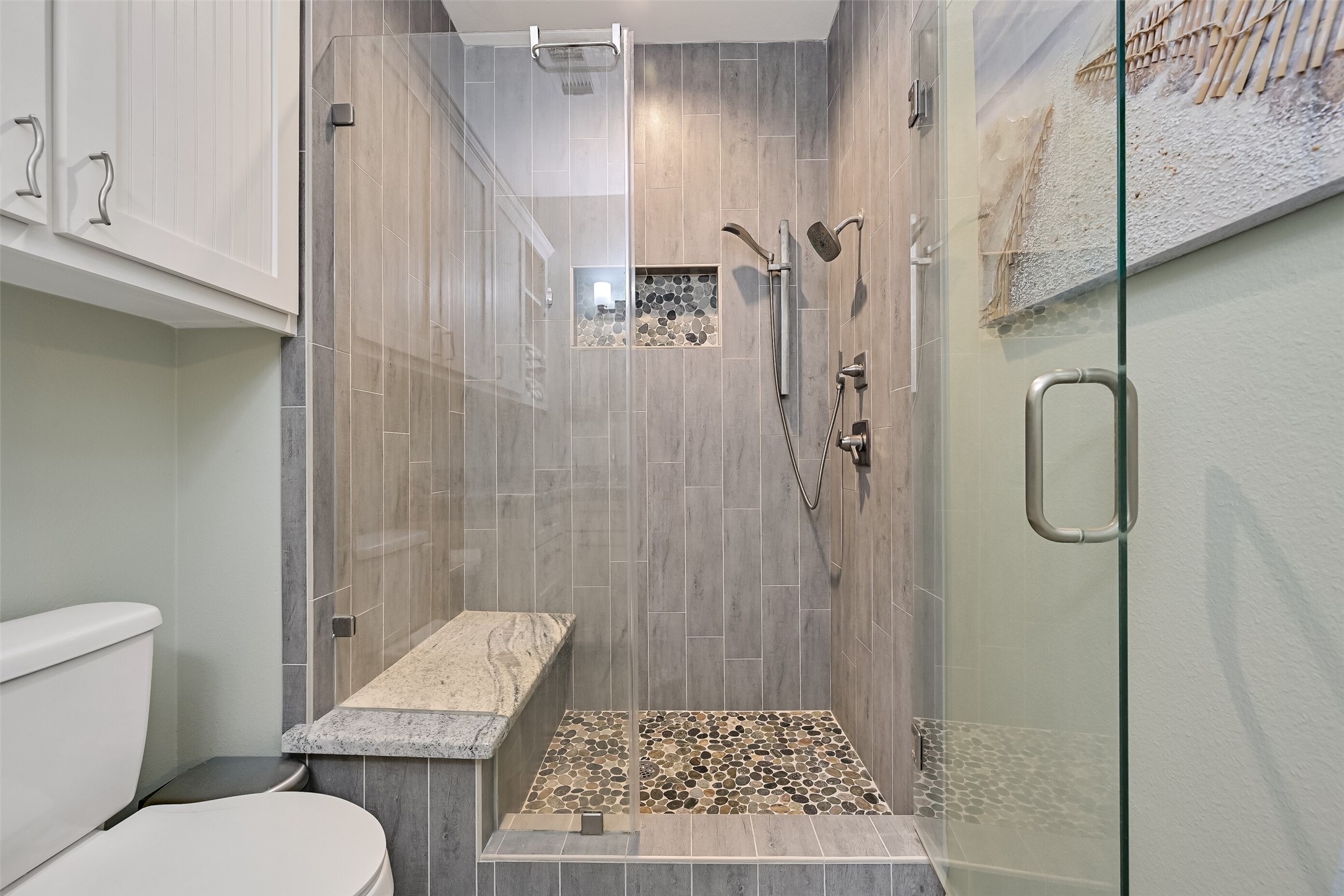 We have the same spa-like shower with a tiled enclosure, pebble floor, & granite bench.