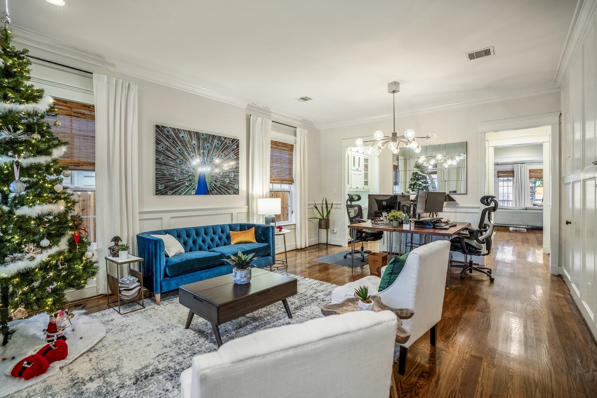 This spacious living room seamlessly flows into the dining space; seen here as home office. Upgraded woodwork on the walls help elevate this luxurious home. The white wood panels to the right of this picture includes a door that opens up to a closet/storage under the stairs. This spacious living room seamlessly flows into the dining space; seen here as home office. Upgraded woodwork on the walls help elevate this luxurious home. The white wood panels to the right of this picture includes a door that opens up to a closet/storage under the stairs.