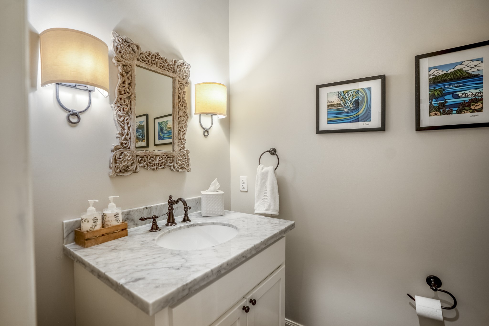 Adorable and nicely curated first-floor powder bathroom with sconce lighting.