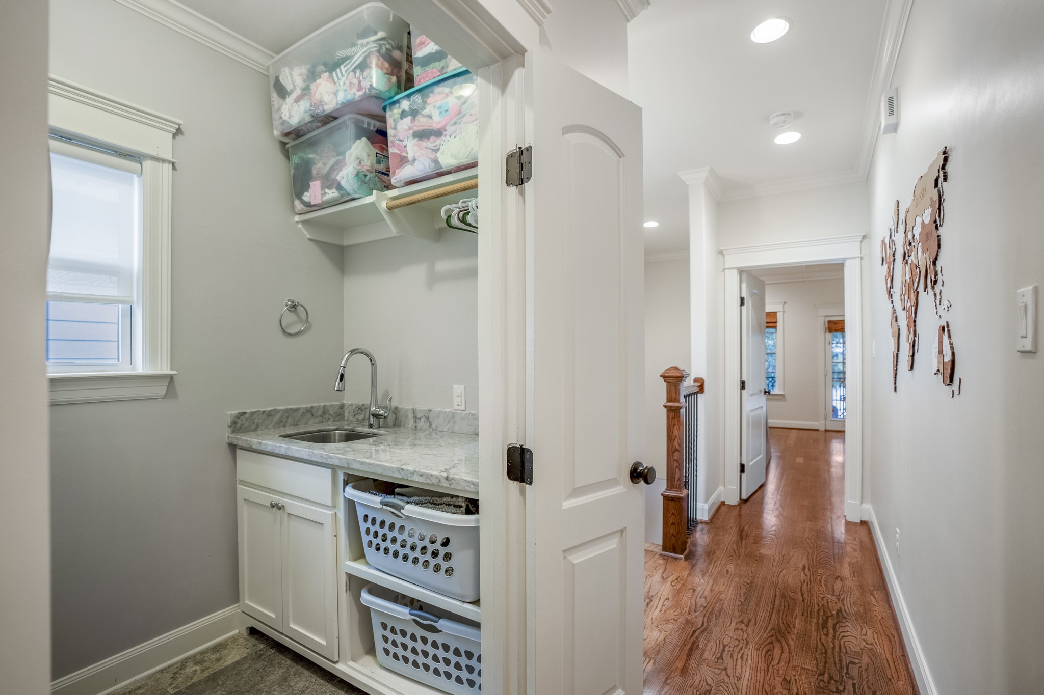 Down the hallway to the other two bedrooms is your utility room with a folding counter and a sink.