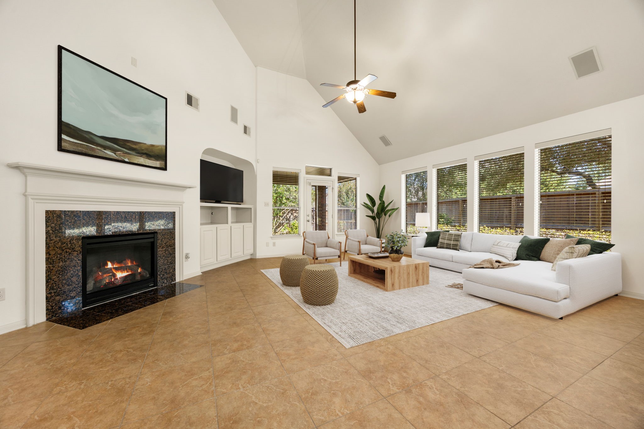 A handsome fireplace with a rich, dark granite surround and detailed white mantel serves as the ultimate living room centerpiece, perfectly complemented by a custom built-in entertainment center. *Virtually Staged
