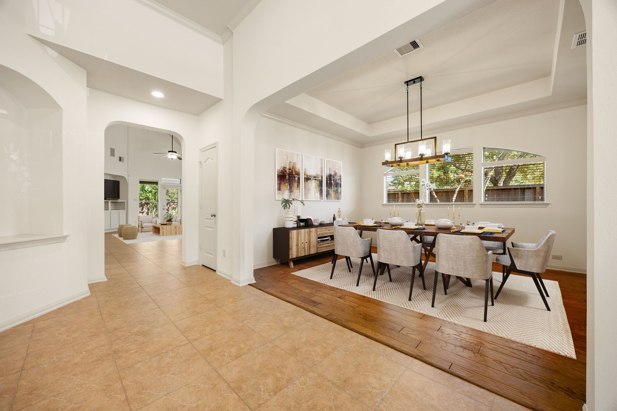 Positioned right off the foyer, the formal dining room boasts exceptional architectural detail, defined by rich engineered wood flooring that beautifully contrast with the home's main tile walkways. It also features tray ceiling, a modern chandelier, and a bank of windows that brightens this dining space. *Virtually Staged Positioned right off the foyer, the formal dining room boasts exceptional architectural detail, defined by rich engineered wood flooring that beautifully contrast with the home's main tile walkways. It also features tray ceiling, a modern chandelier, and a bank of windows that brightens this dining space. *Virtually Staged