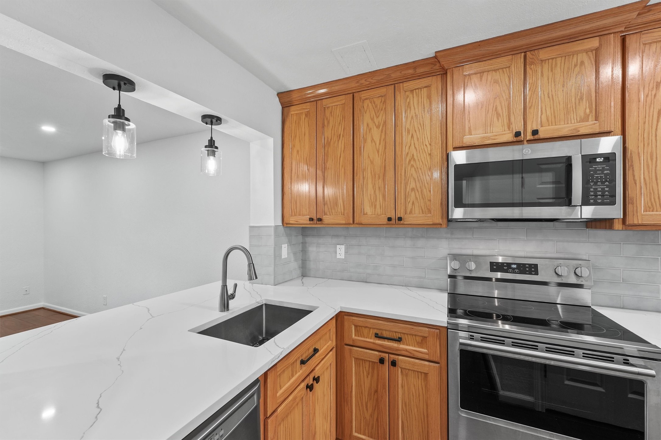 Breakfast bar in the kitchen with quartz countertops and upgraded pendant lighting