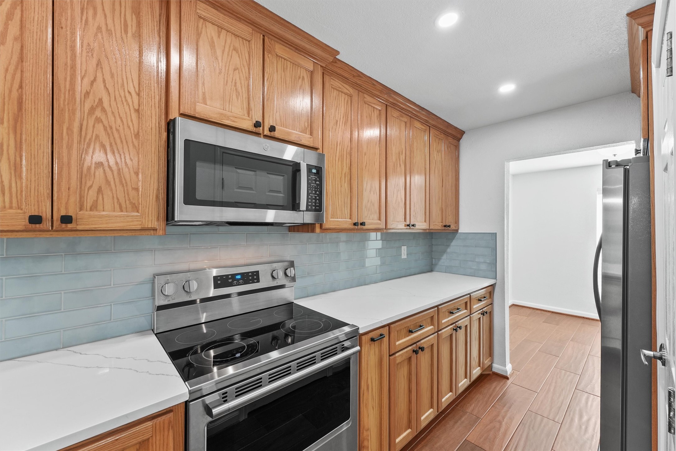 Quartz countertops, upgraded subway tiled backsplash, stainless steel appliances with custom wooden cabinetry and hardware