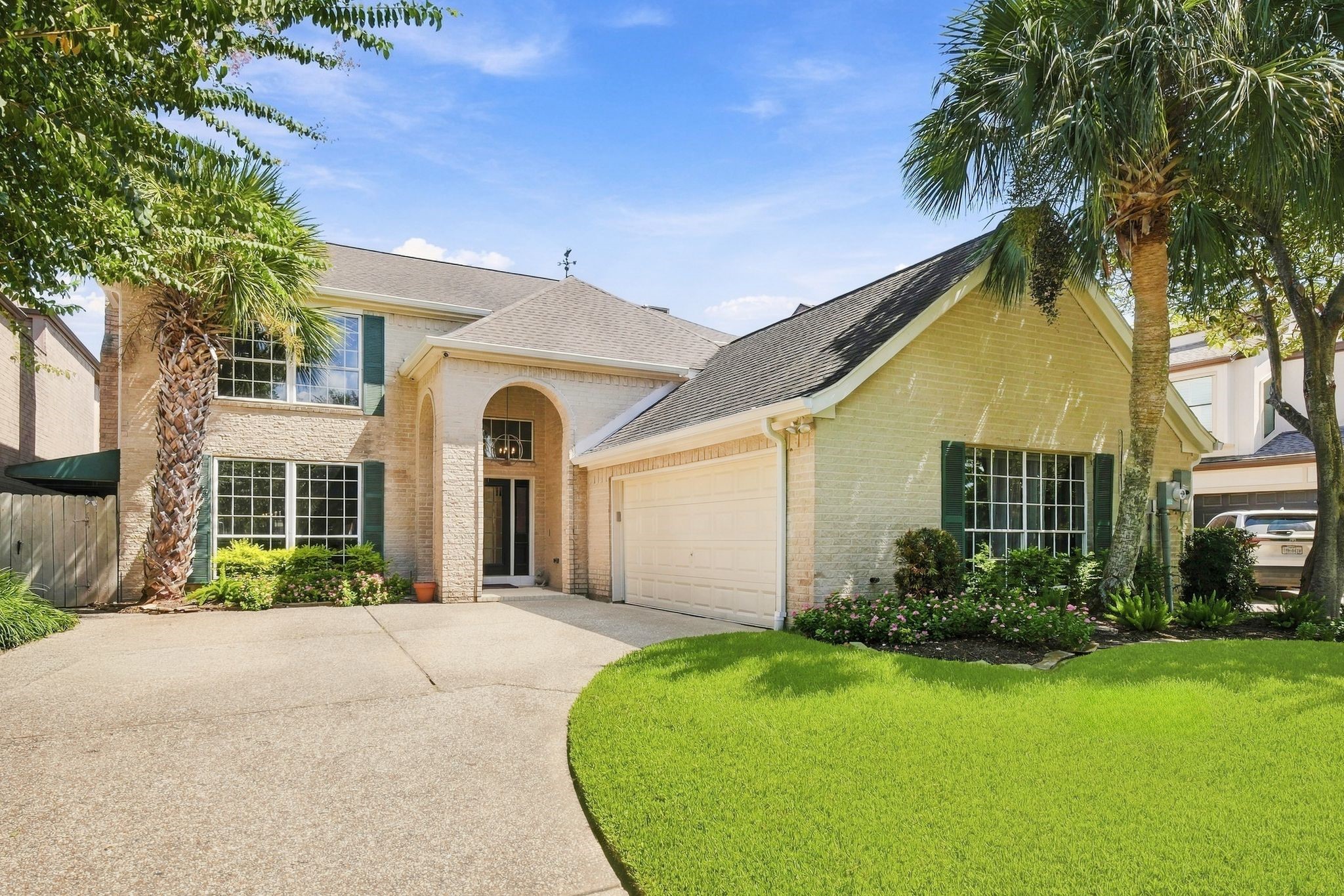 The front elevation features a classic brick exterior, an arched entry, and a double-wide driveway. The front elevation features a classic brick exterior, an arched entry, and a double-wide driveway.