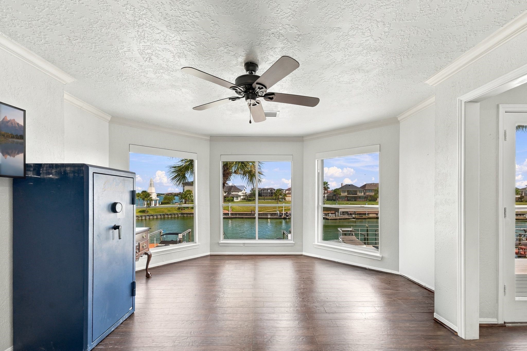 The primary suite has a bright sitting area with a wall of windows overlooking the water.