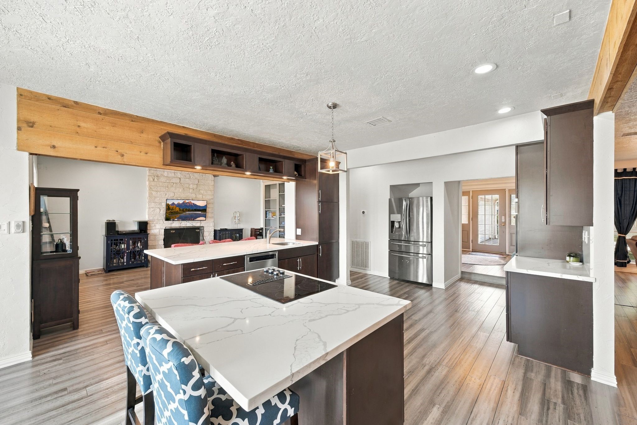 The island has a cooktop, quartz countertops, and a breakfast bar.
