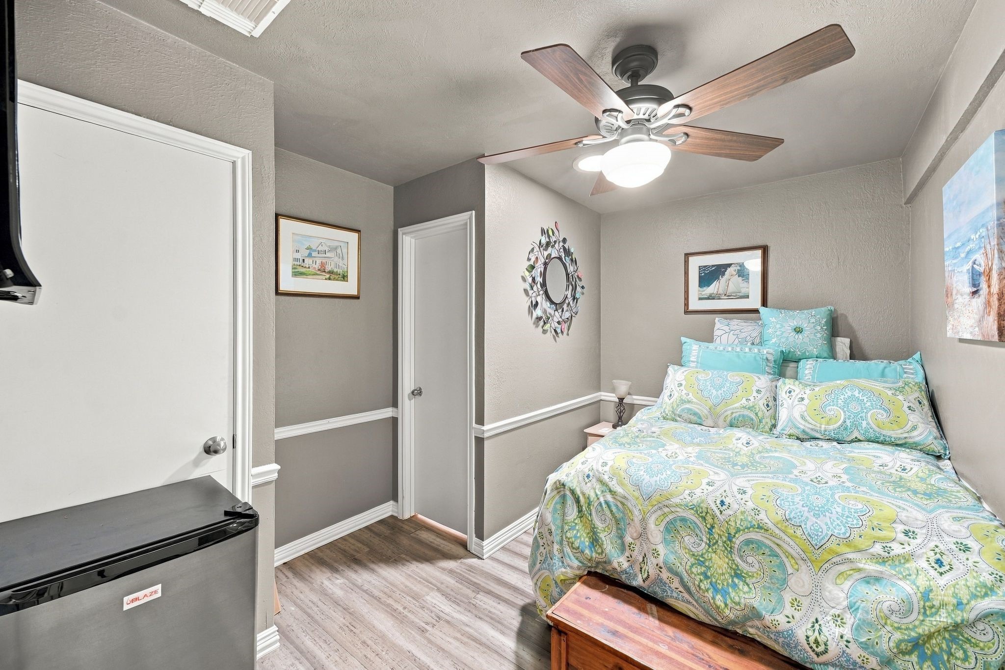 The secondary bedroom features detailed trim and updated flooring.