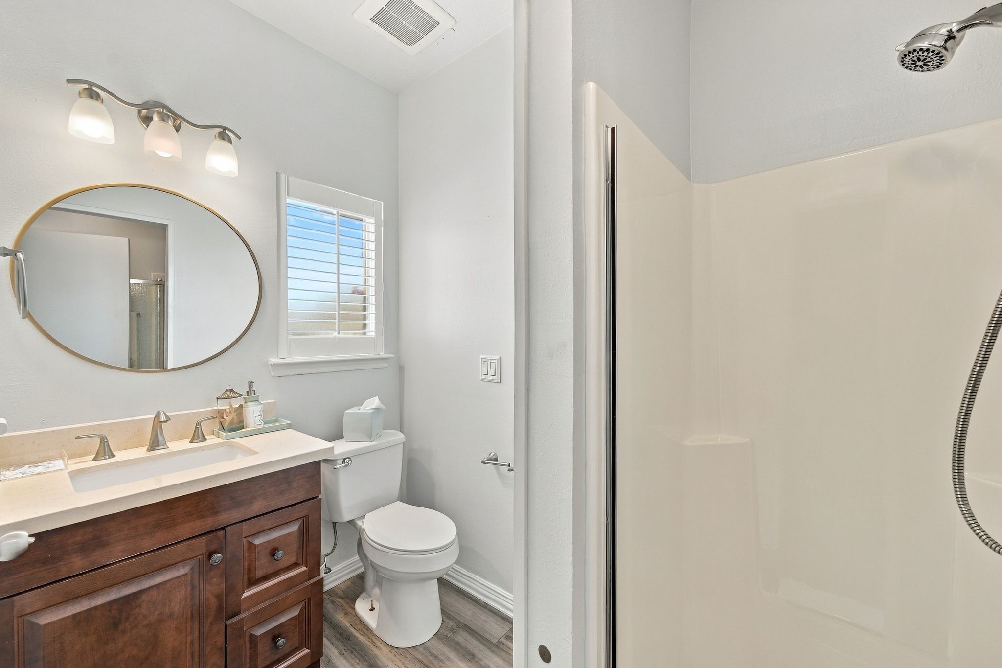 The full bathroom features a single vanity and a walk-in shower.