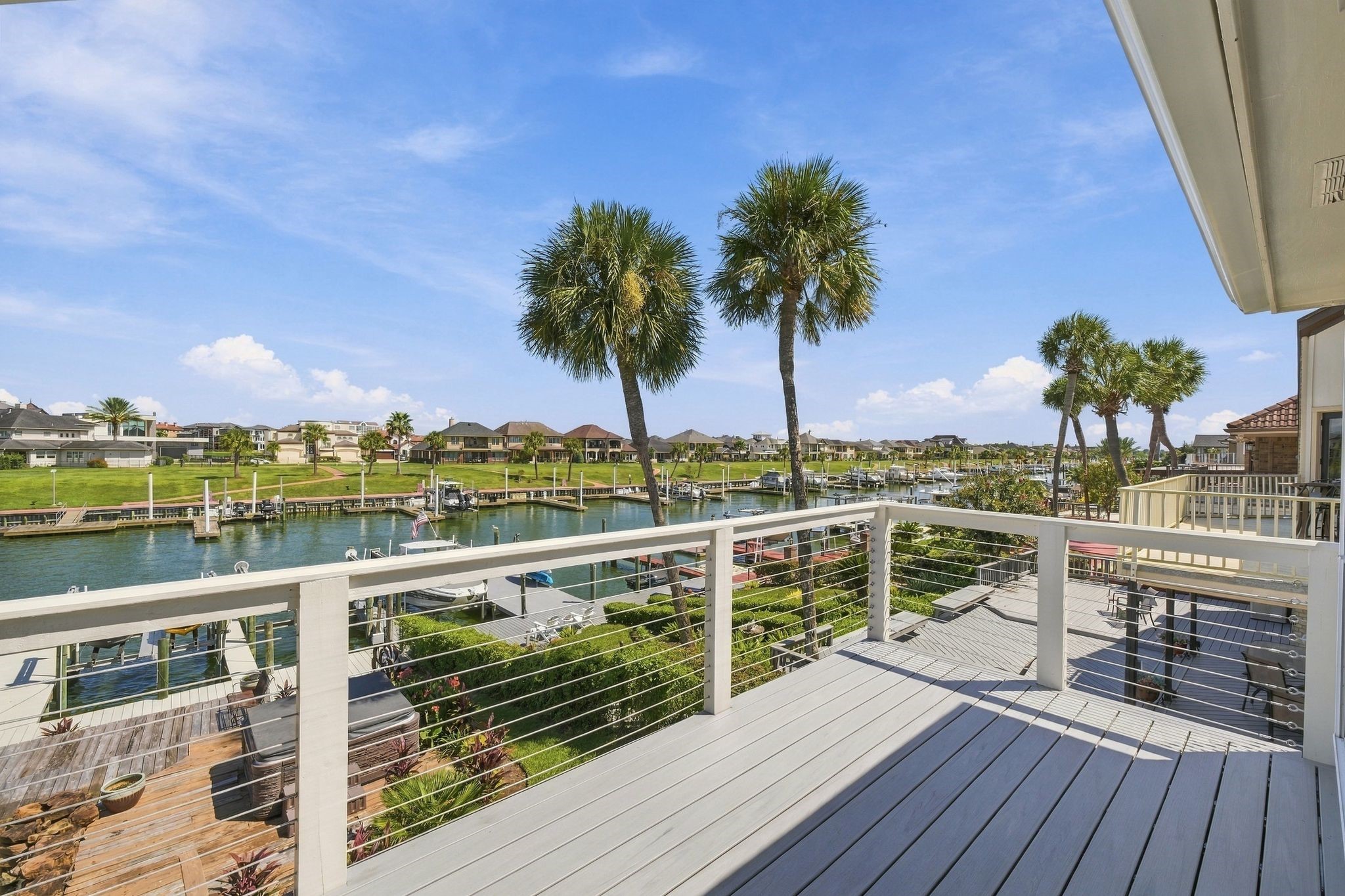 The private balcony overlooks open water and palm trees.