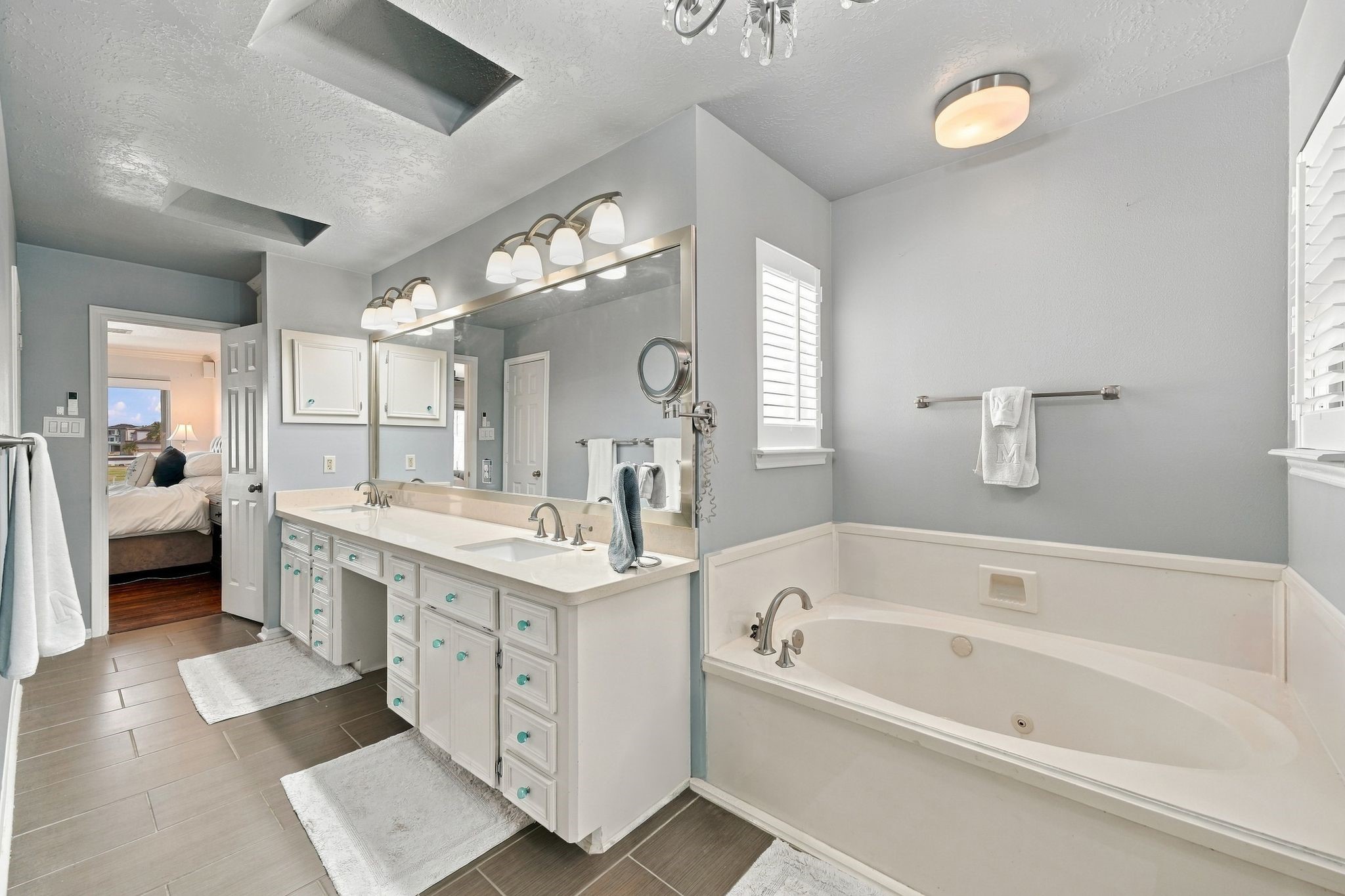 The primary bath features a soaking tub, dual vanity sinks, and a built-in makeup vanity.