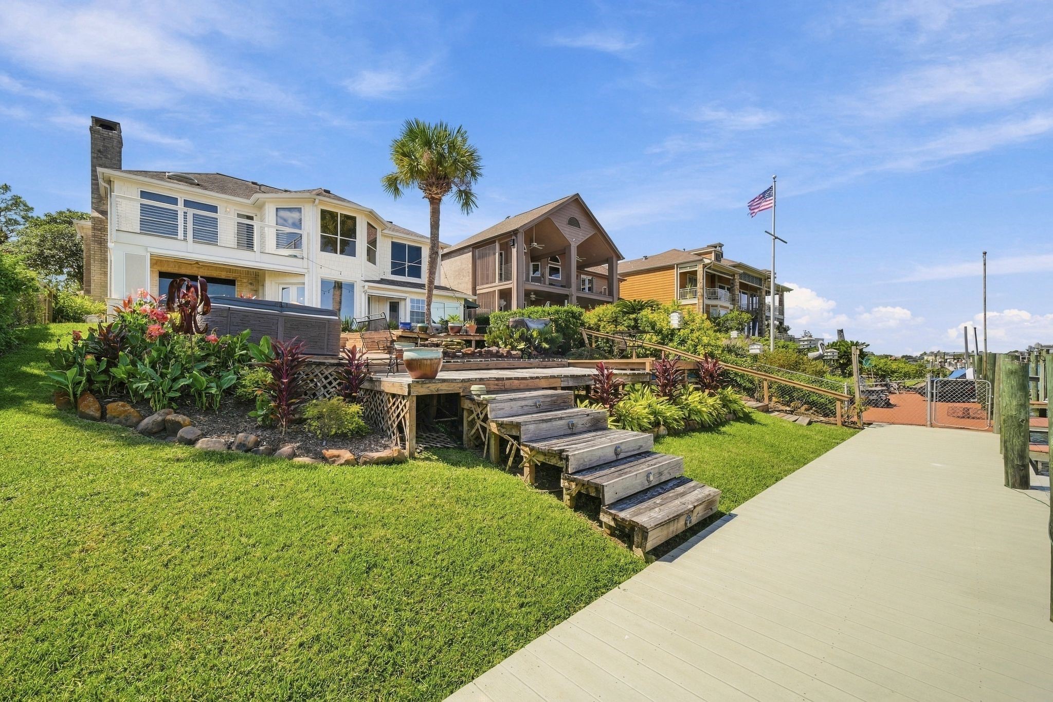 The backyard includes a hot tub for relaxing by the water.