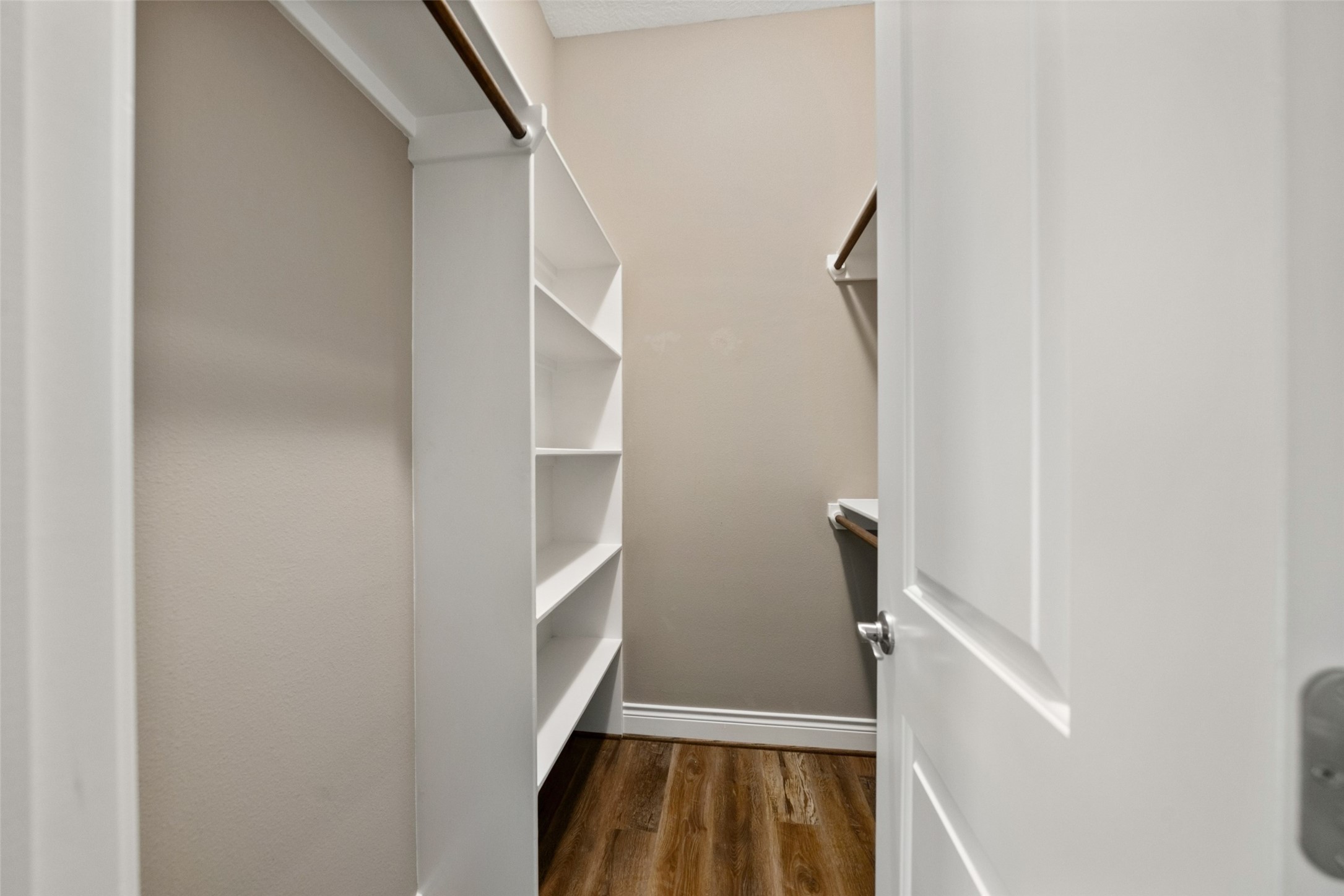 Walk-in storage area with built-in shelving and hanging space.