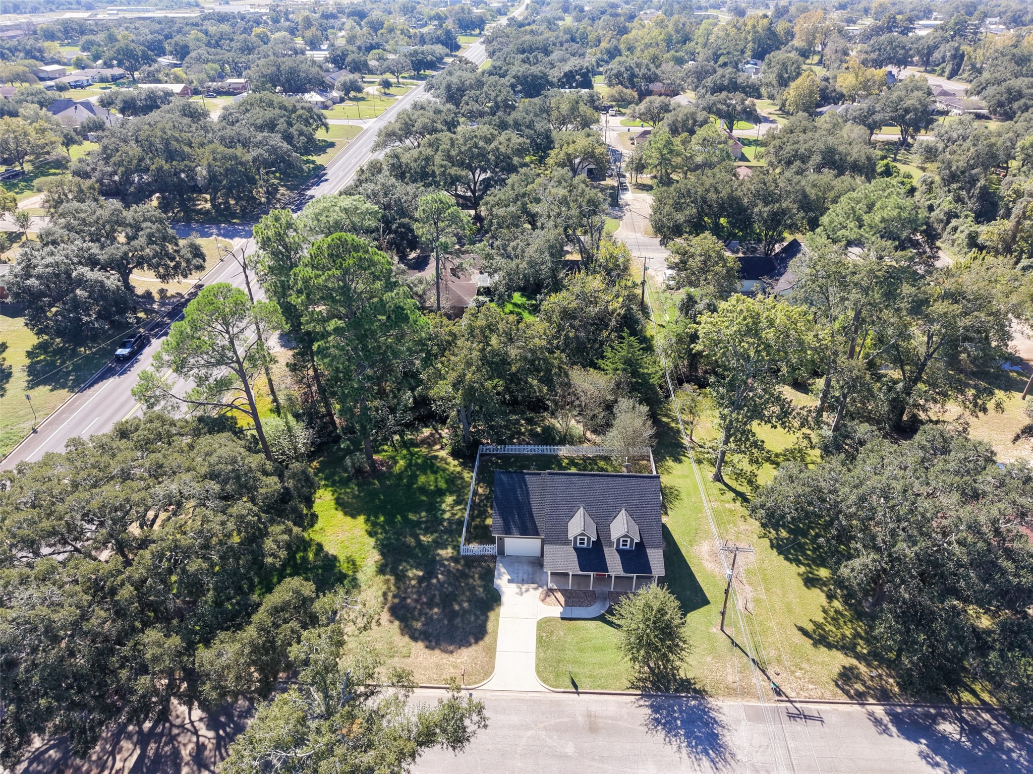 Overhead neighborhood view showing the propertys setting among established trees and nearby residences.