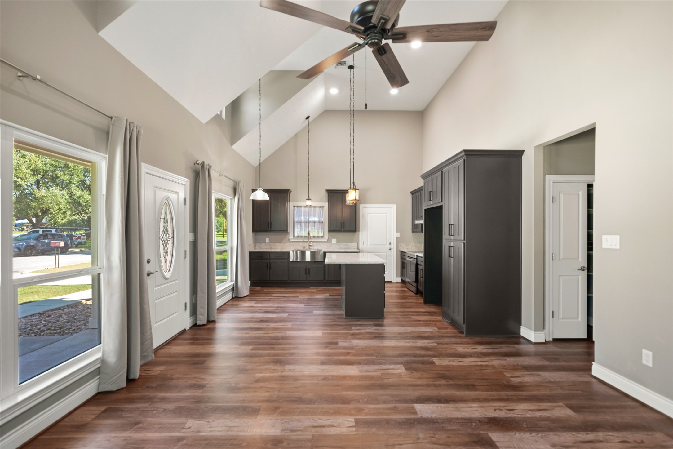 View toward the kitchen highlighting the open layout, large windows, and center island.