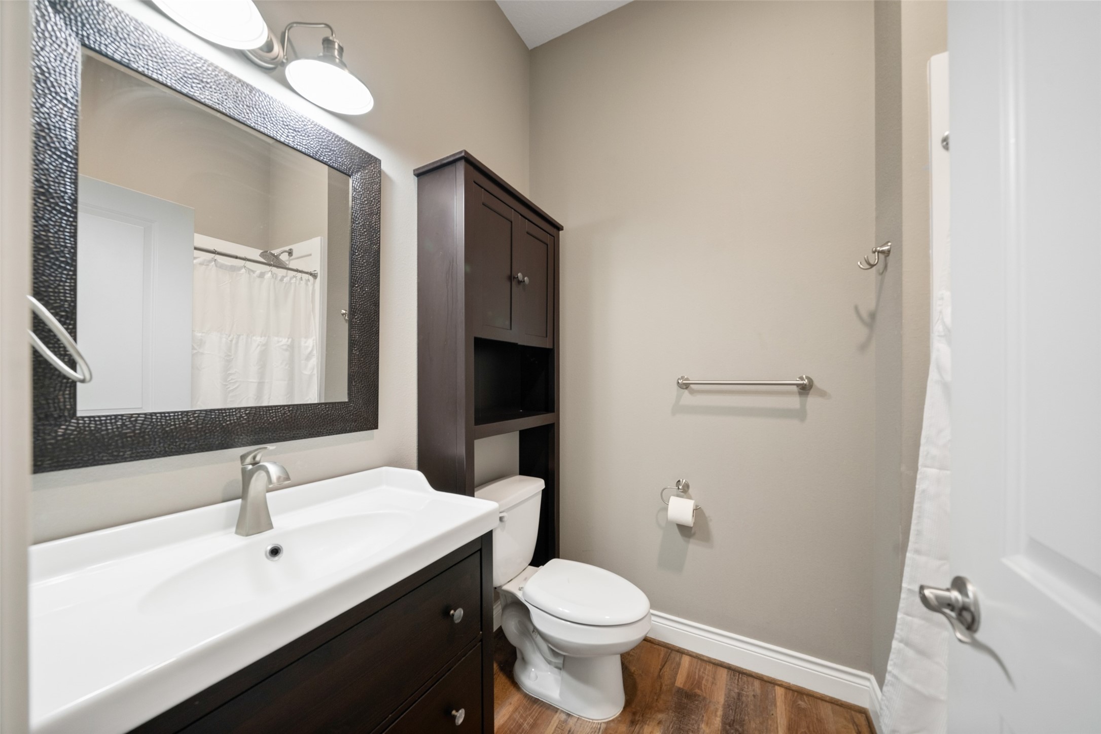 Bathroom featuring a wide vanity, framed mirror, overhead lighting, and a tub/shower combination.